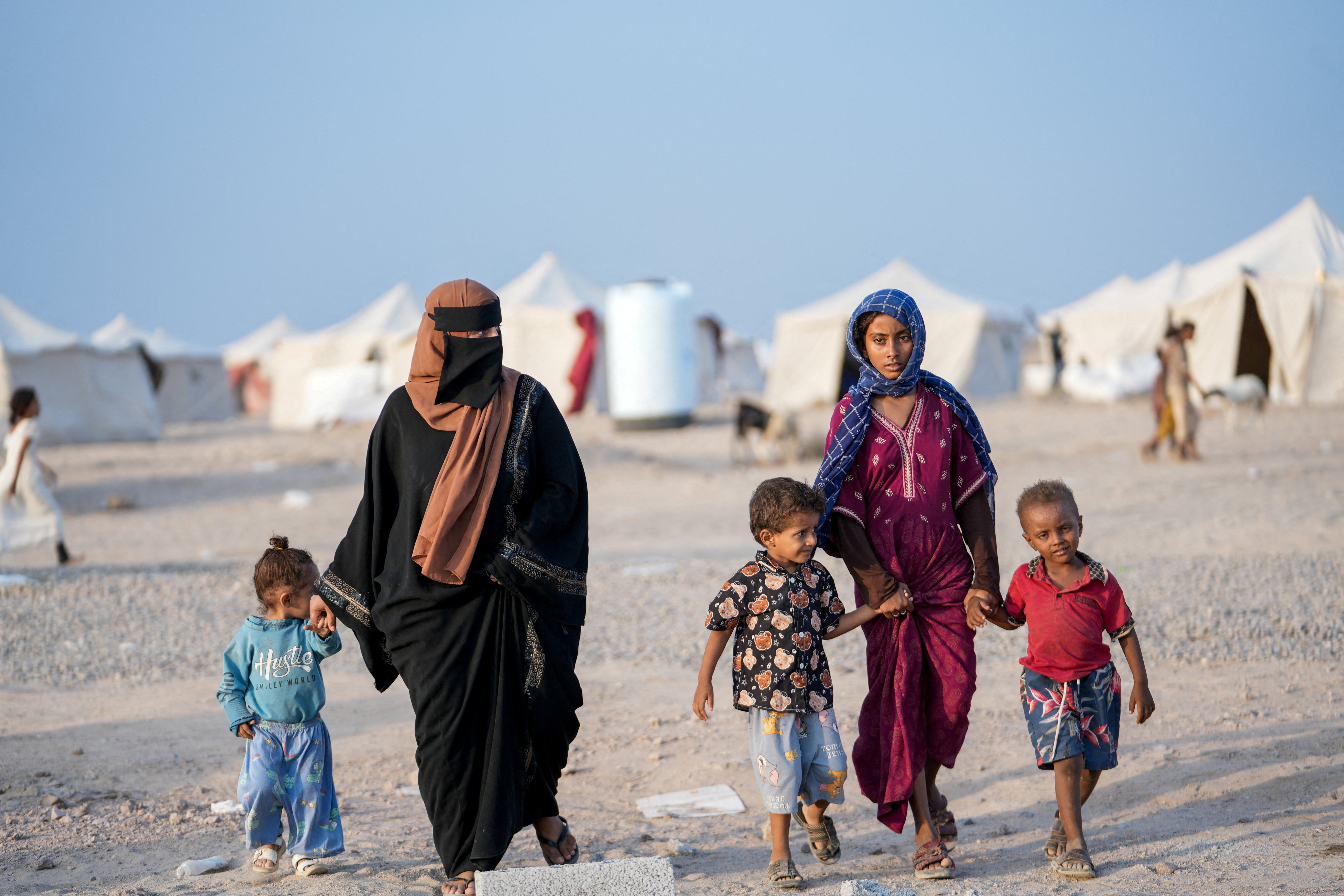 Women and children, who fled fighting between the Houthis and government forces in Red Sea coastline areas, walk at a camp for internally displaced people near Aden, Yemen on September 19, 2026 [Reuters]