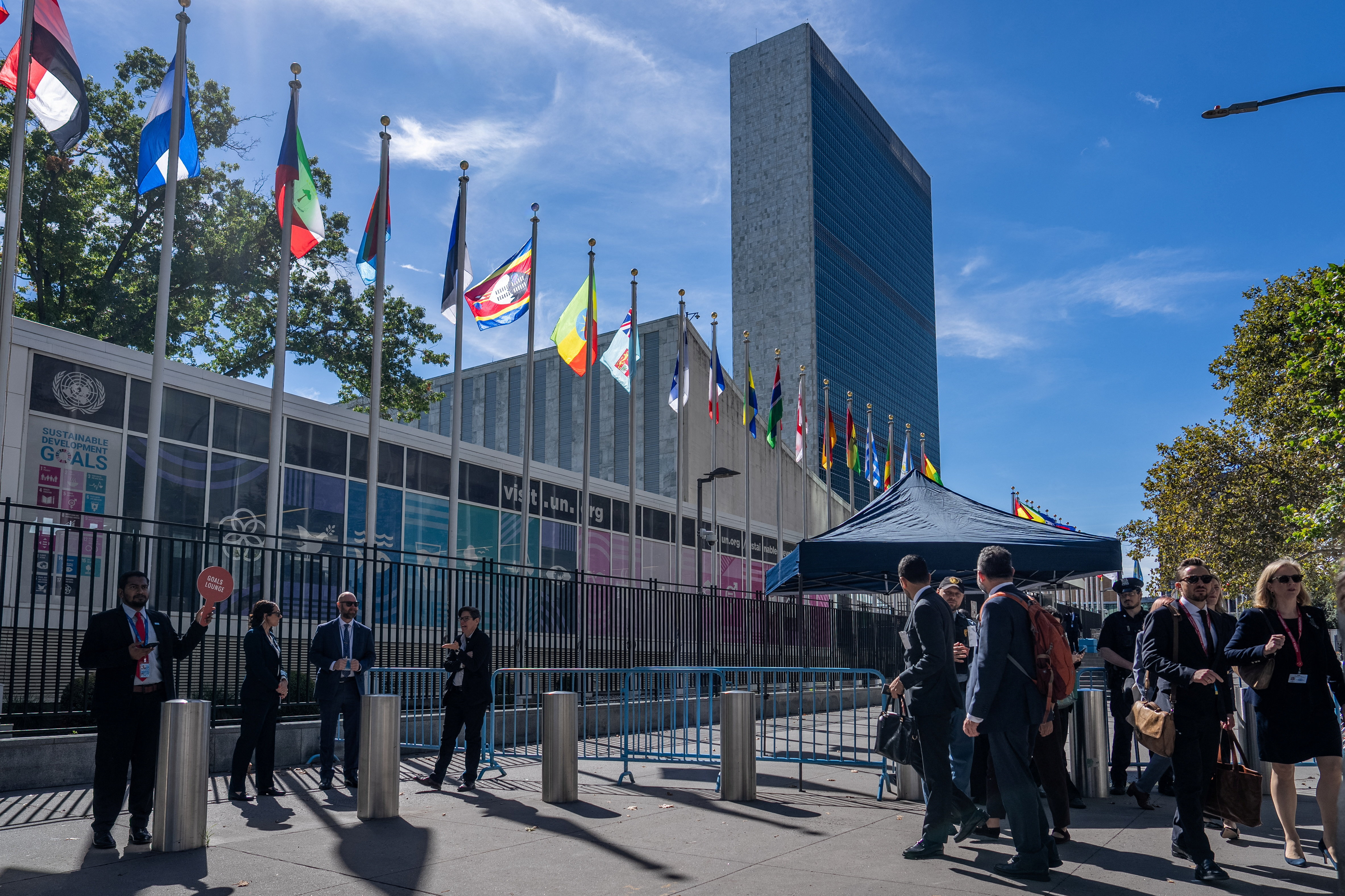 Pedestrians on the pavement outside the UN headquarters building in New York