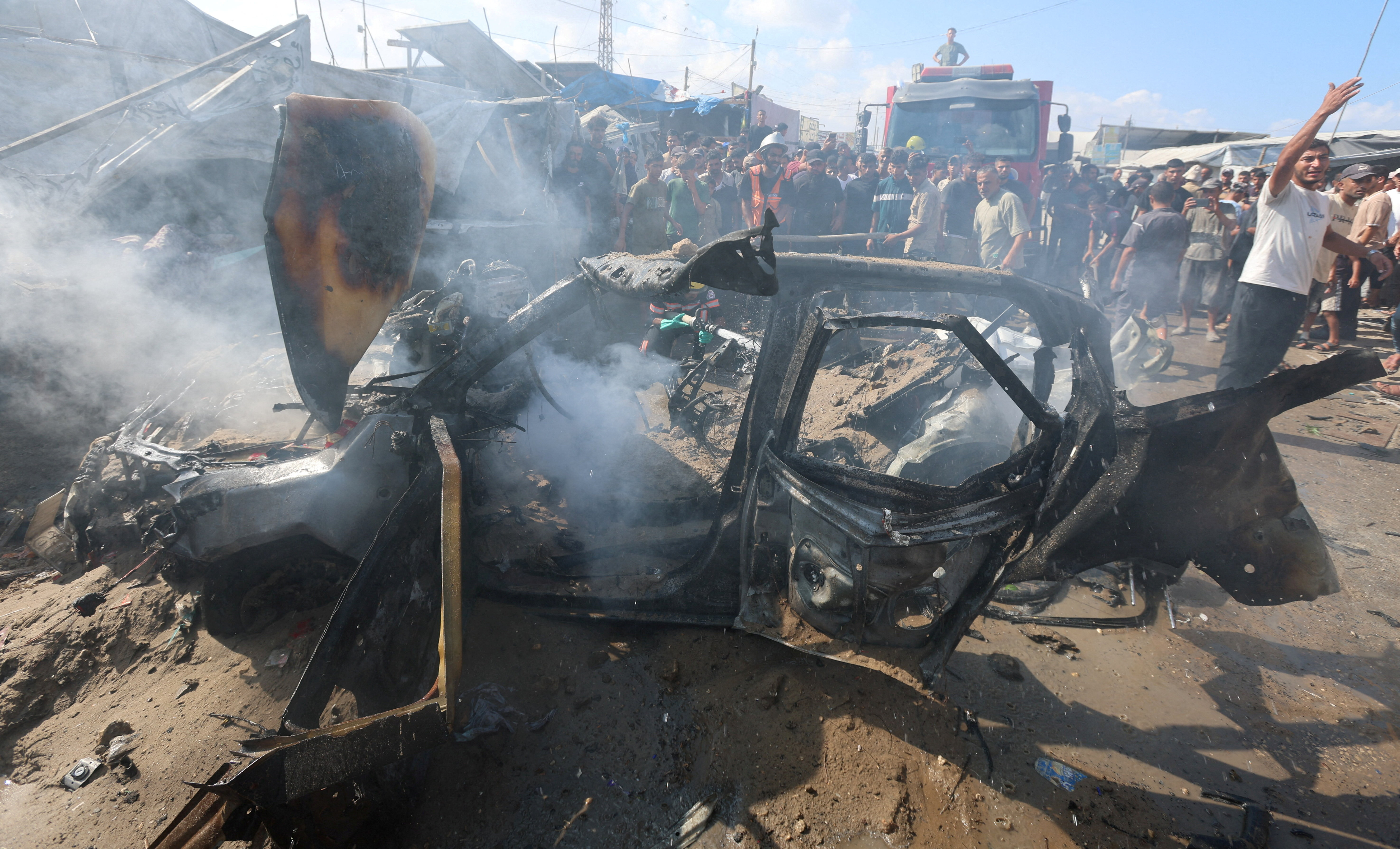 Palestinians inspect a vehicle hit by an Israeli airstrike in Khan Younis in the southern Gaza Strip, September 23, 2026 [Ramadan Abed/Reuters]