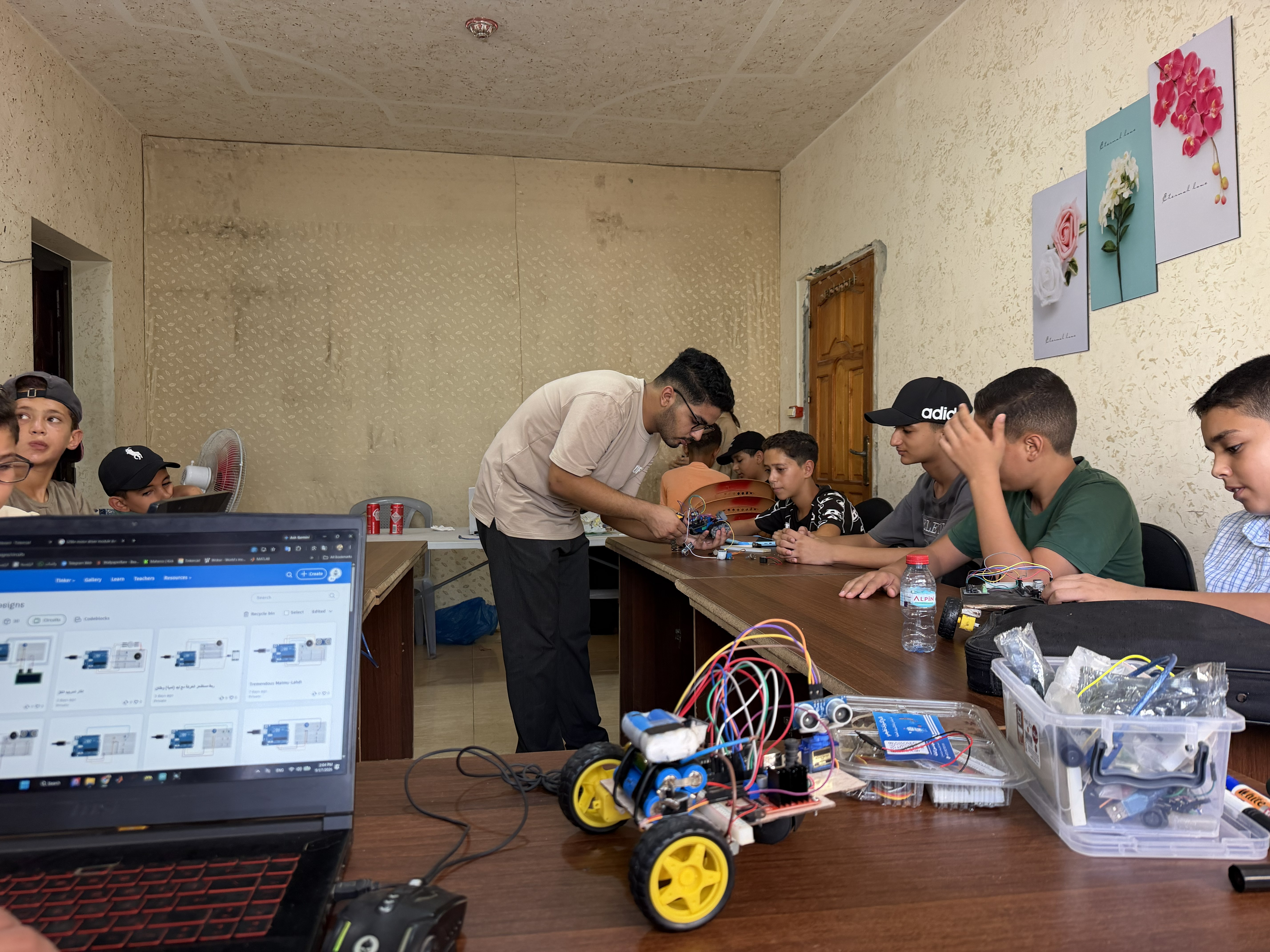 Engineer Bahaa Al-Masry during a training workshop for children on control and alarm systems and manufacturing robots, using simple electronic tools and equipment [Iyad Al-Qatrawi/Al Jazeera]