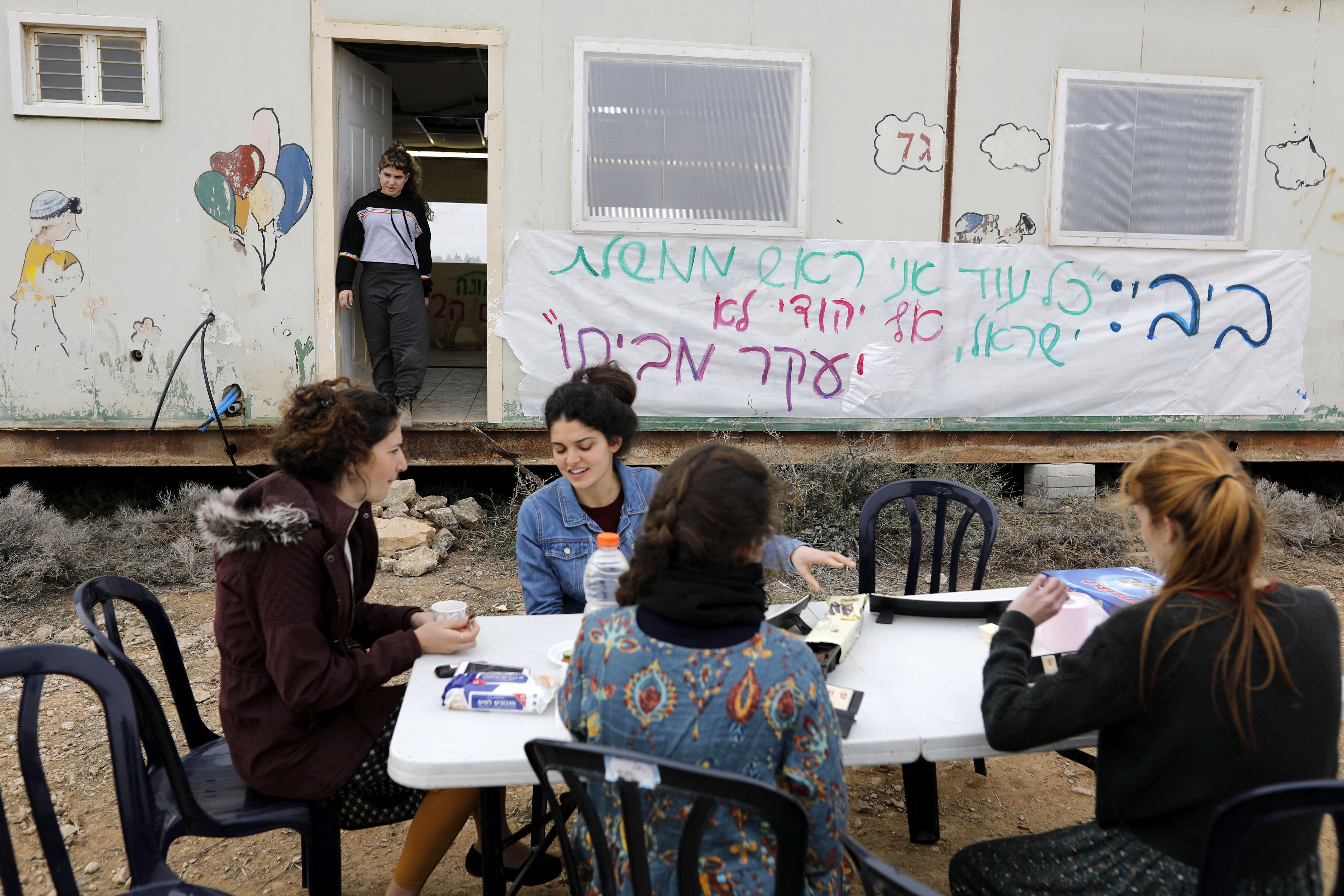 This picture shows Israeli youths near new barracks at the former Amona outpost near the Settlement of Ofra, in the west bank, on December 16, 2018, after settlers announced that they had begun to rebuild the Amona outpost to protest a new wave of Palestinian attacks. The Amona outpost was evacuated and demolished by the Israeli army in 2017 following a Supreme Court decision ruling that Amona was built on private Palestinian property and must be evacuated. Israeli Prime Minister Benjamin Netanyahu will legalise thousands of settlement homes built without even Israeli permits in the occupied West Bank following a deadly attack, he announced on December 13. (Photo by MENAHEM KAHANA / AFP)