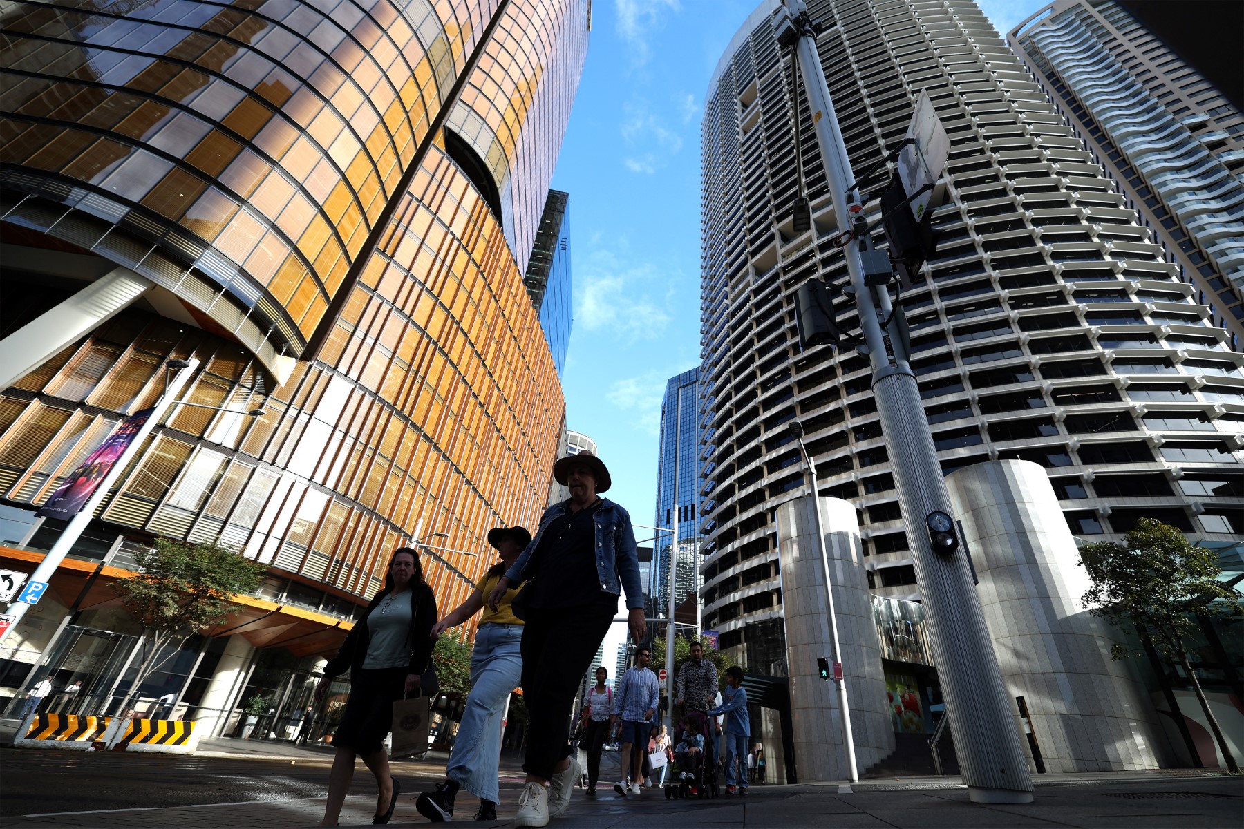 People walk among high-rise buildings.