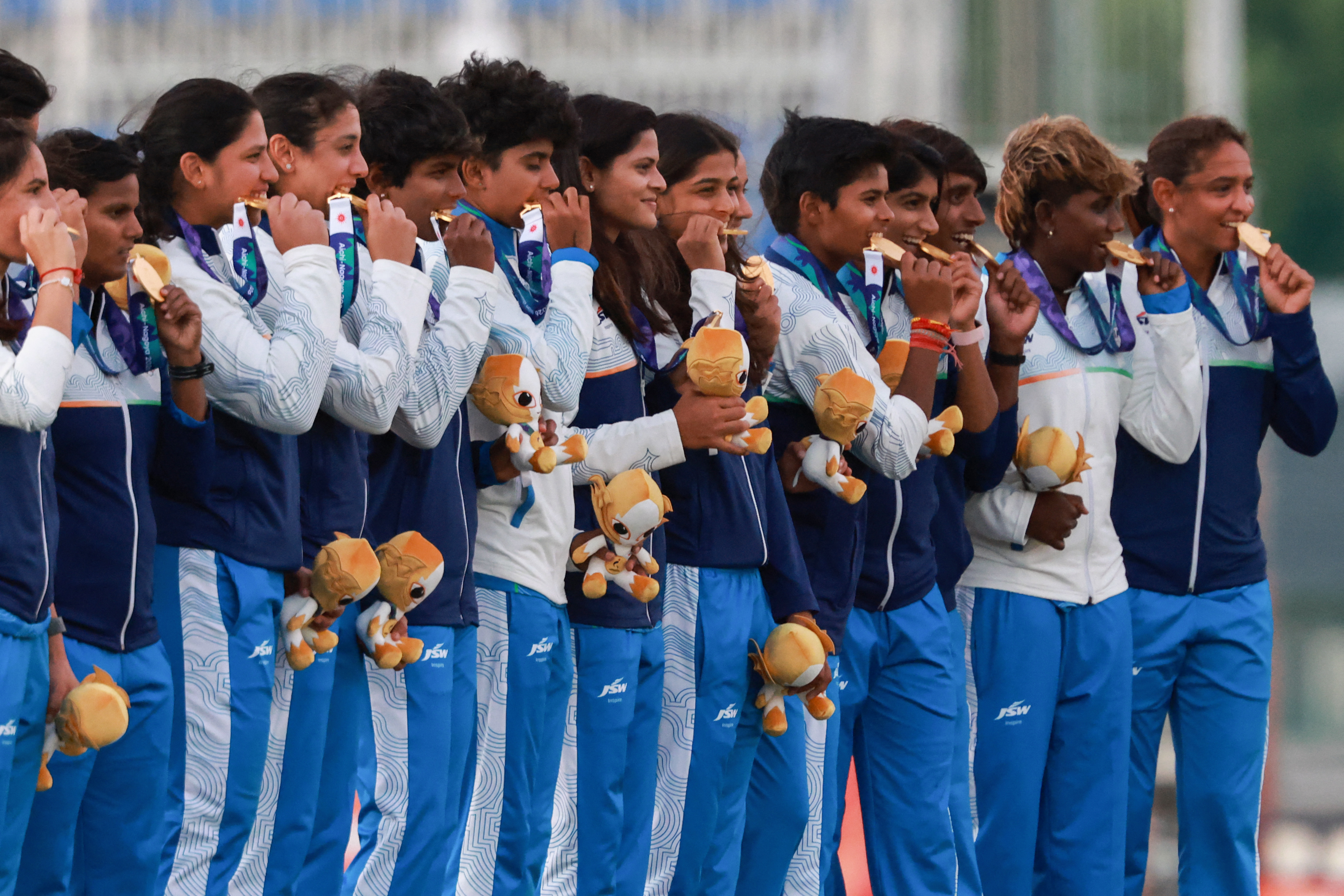 Gold medallists India pose on the podium.