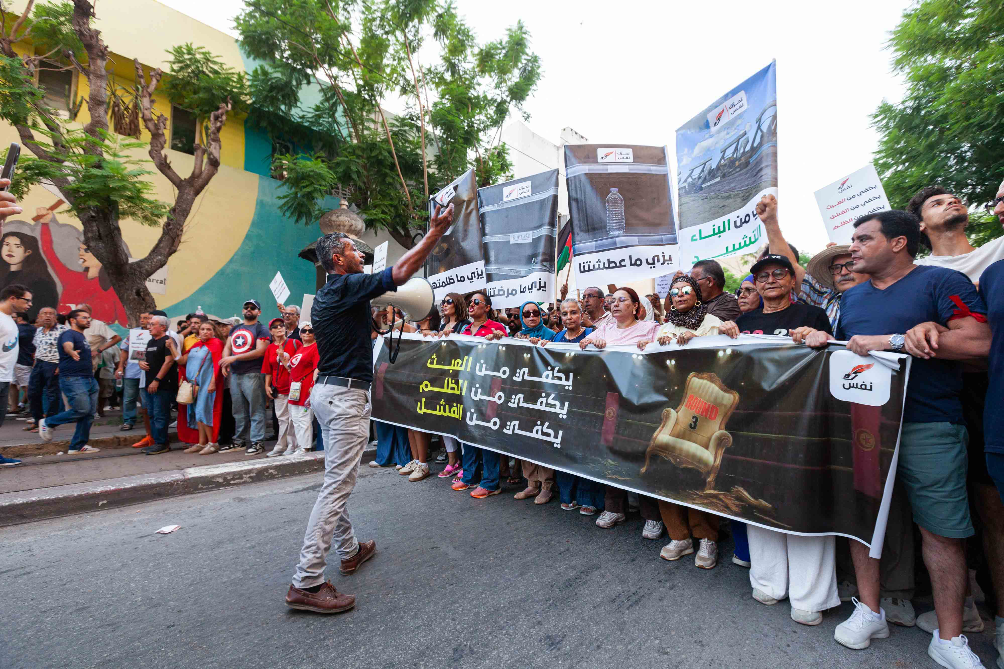 People protest against rising prices, declining purchasing power and shortages of basic goods in Tunis, Tunisia, on Thursday, August 20, 2026. The banner in Arabic reads, “Enough injustice, enough failure.” [Ons Abid/AP]