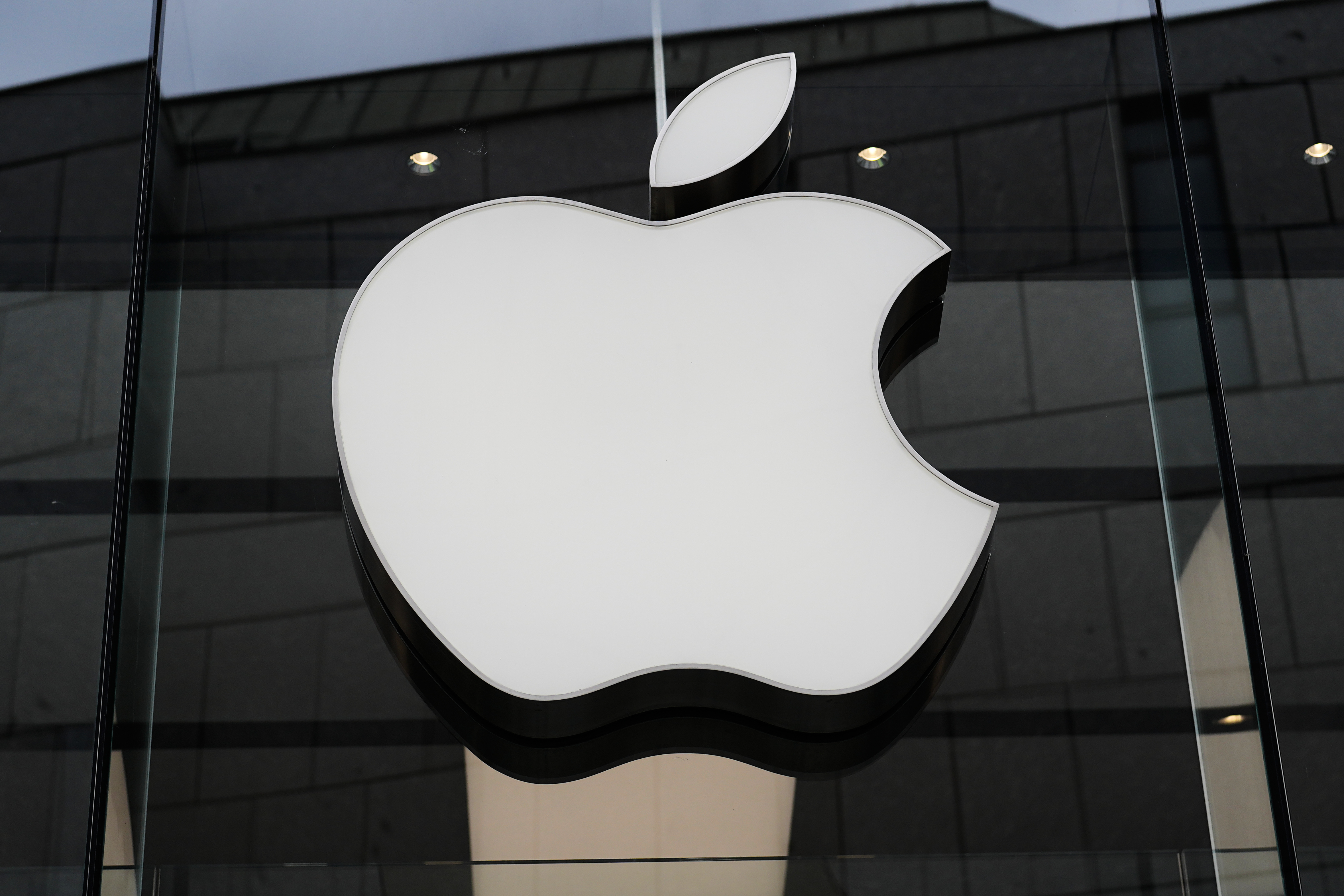 The Apple logo is illuminated at a store in Munich, Germany, on April 2, 2026