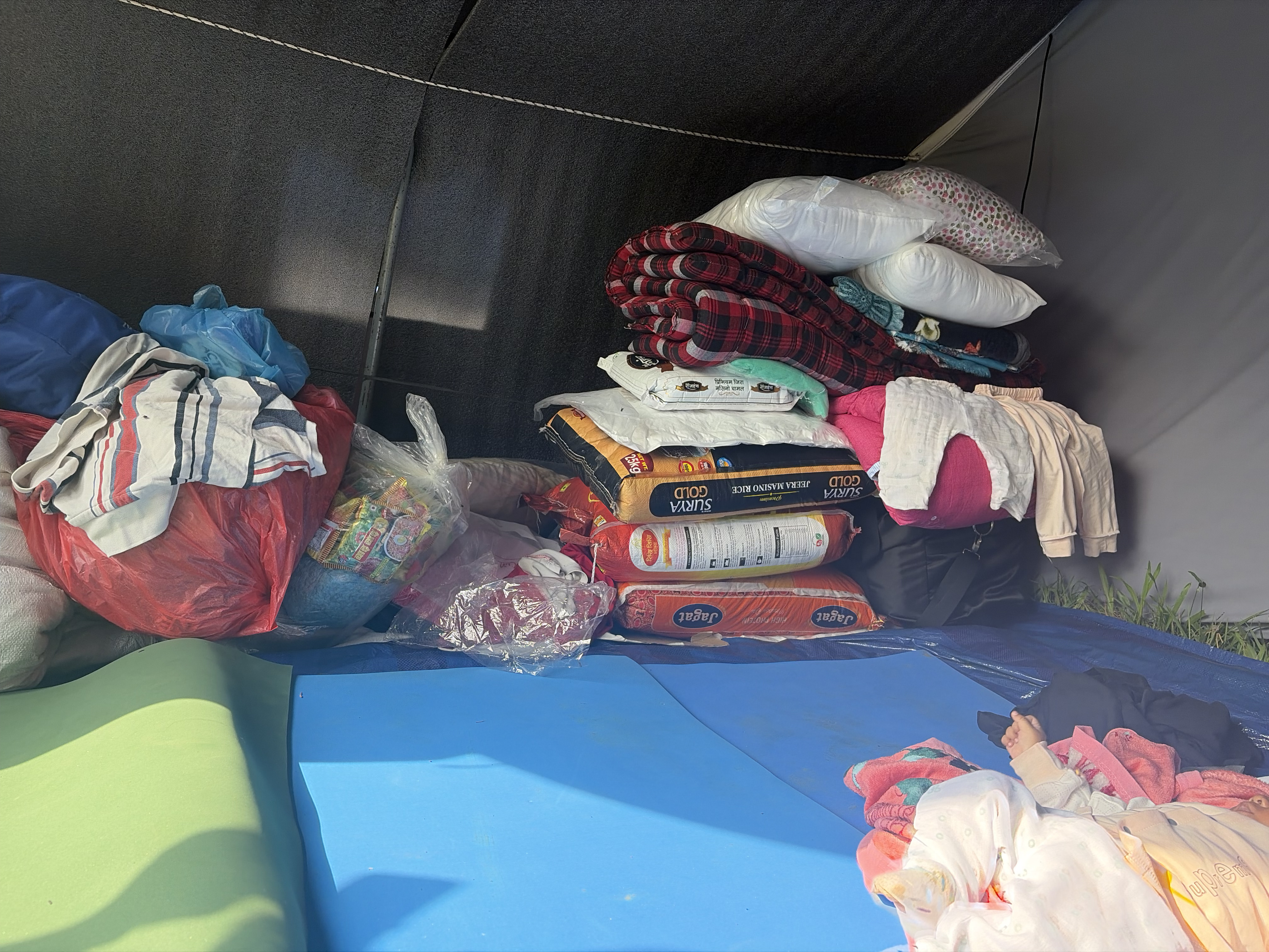 Bedding, relief materials and packaged food are kept inside a child-friendly shelter tent in Nuwakot.