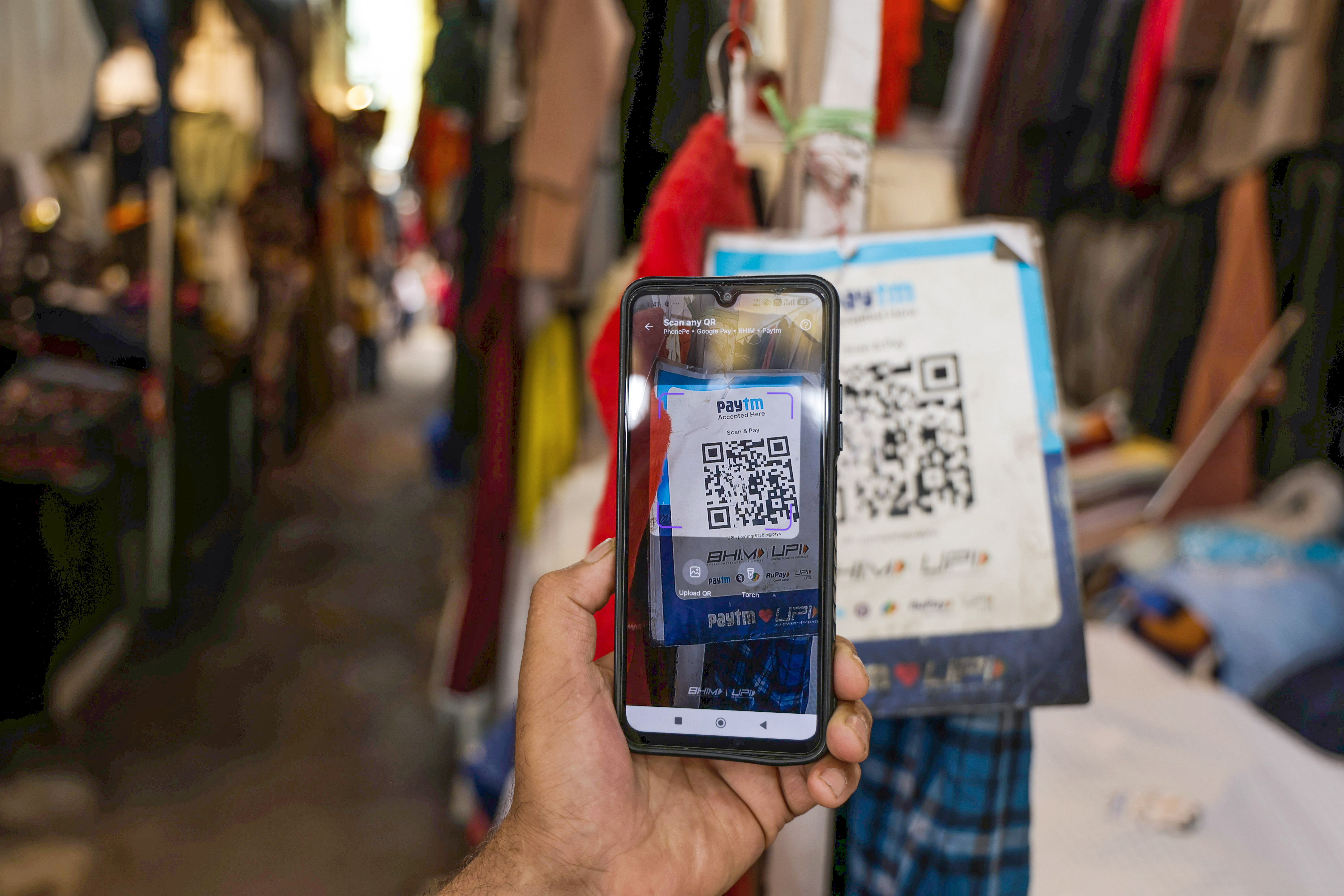 epa13243561 A customer makes a payment through the Unified Payments Interface (UPI) at a shop in Srinagar, the summer capital of Indian Kashmir, 16 September 2026. India's new UPI Merchant Discount Rate framework, effective October 15, will impose a 0.4 percent charge on merchant transactions above INR 2,000 (about USD 21), capped at INR 300 (about USD 3.10) per transaction, while person-to-person payments will remain free; the change is expected to affect how local consumers and small businesses handle higher-value digital payments, although the government has said merchants should not pass the charge on to customers. EPA/FAROOQ KHAN