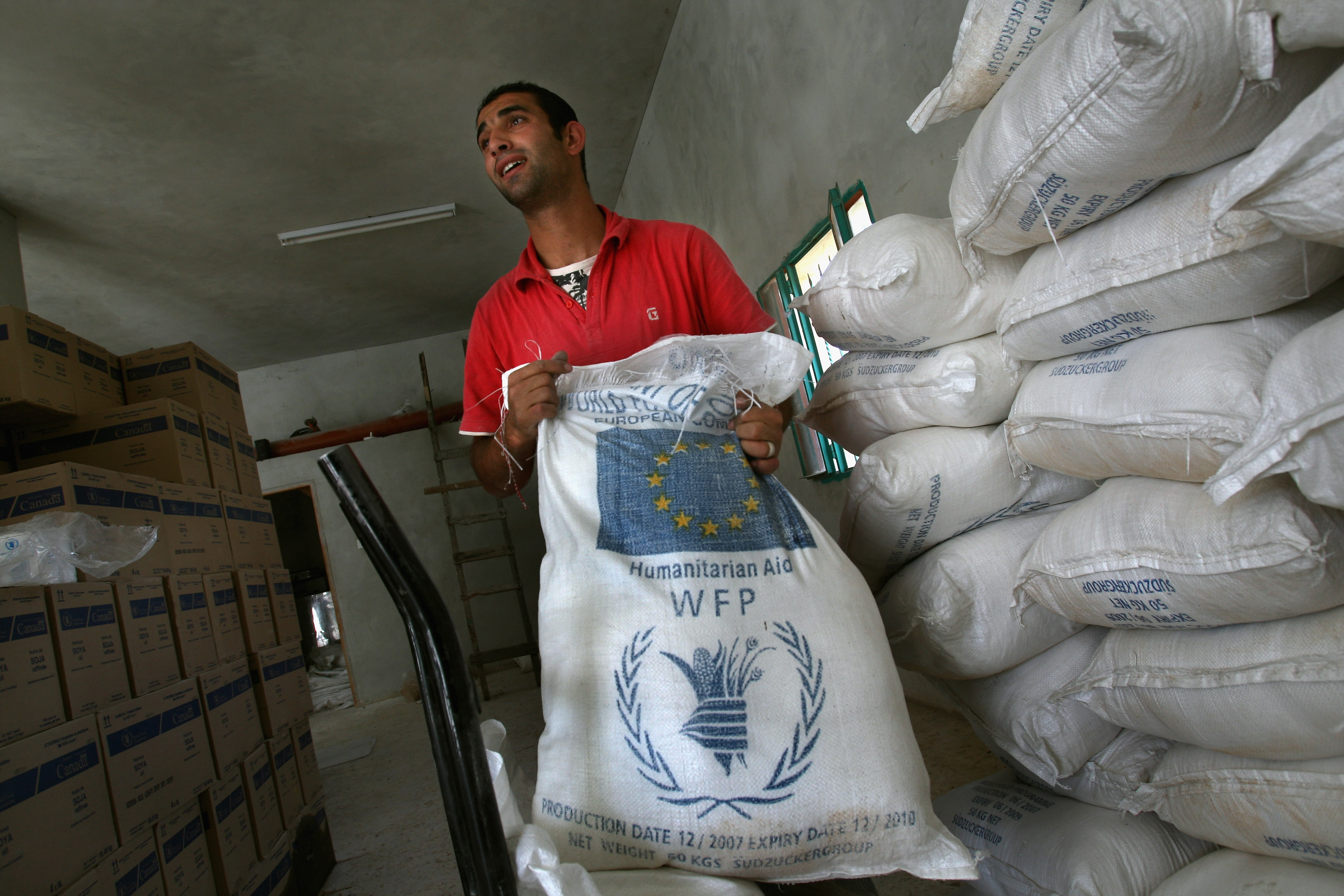 DURA, WEST BANK - APRIL 21: A worker prepares a bi-monthly allocation of enriched flour, oil, salt, sugar and chickpeas for a Palestinian family at a World Food Program (WFP) warehouse April 21, 2008 in the West Bank Palestinian town of Dura. The UN food agency said the world faced a "silent tsunami" of soaring food prices, plunging as many as 100 million people into hunger. WFP head Sheeran has called on governments to make emergency allocations to offset the rising costs associated with procuring and delivering food. (Photo by David Silverman/Getty Images)
