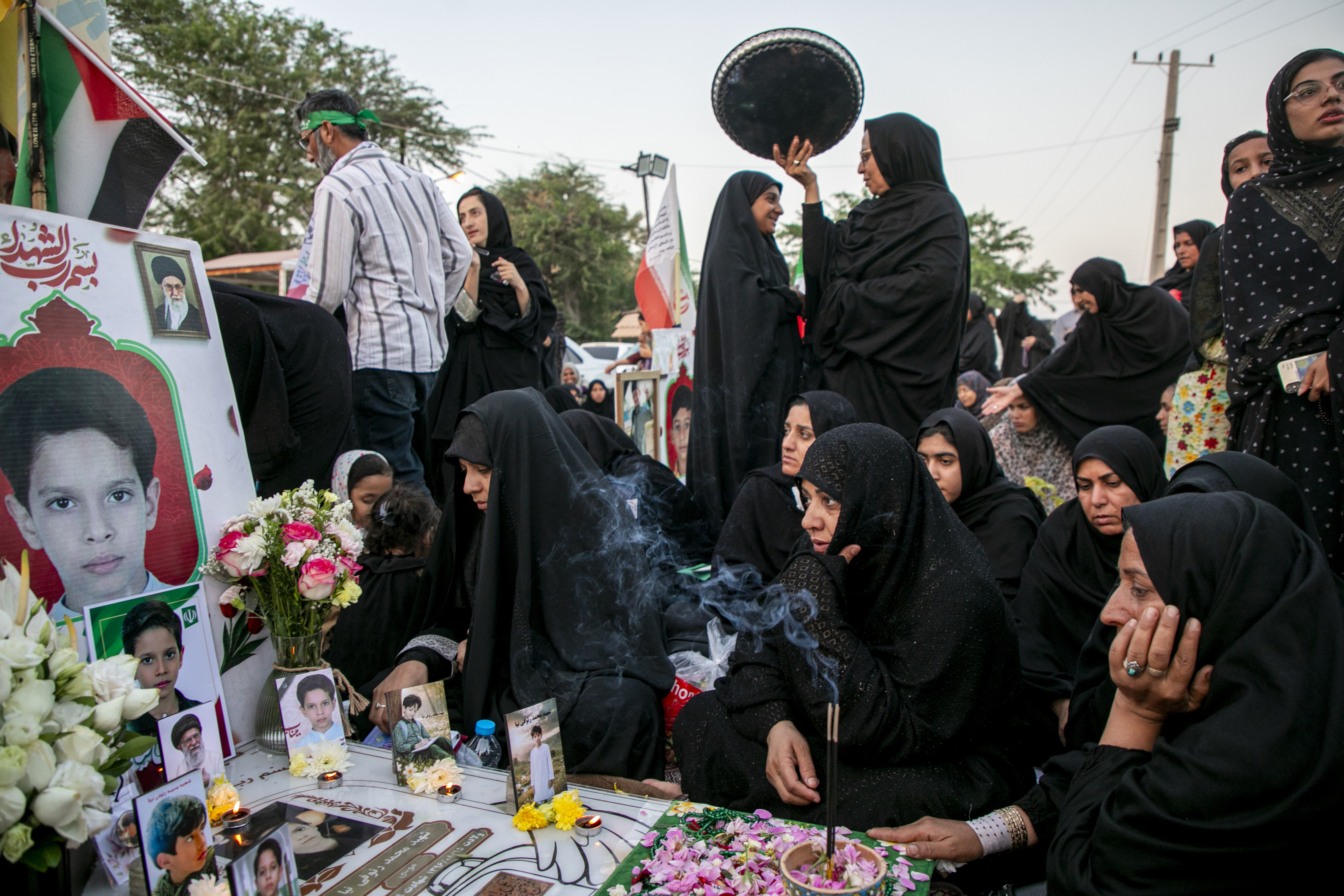 MINAB, IRAN - MAY 14: A group of women gather by a grave to mourn at the cemetery of Minab City on May 14, 2026 in Minab, Iran. On 28 February this year, a US military launched a missile strike that destroyed the all-girls Al-Shajara School in Minab, Iran, killing 175 people, including 47 schoolgirls and 26 teachers and causing global outrage. The attack is the deadliest civilian event of the 2026 Iran war. US investigators later stated American forces hit the school by mistake due to outdated intelligence, as the civilian school sat right next to an Iranian naval base. (Photo by Majid Saeedi/Getty Images)