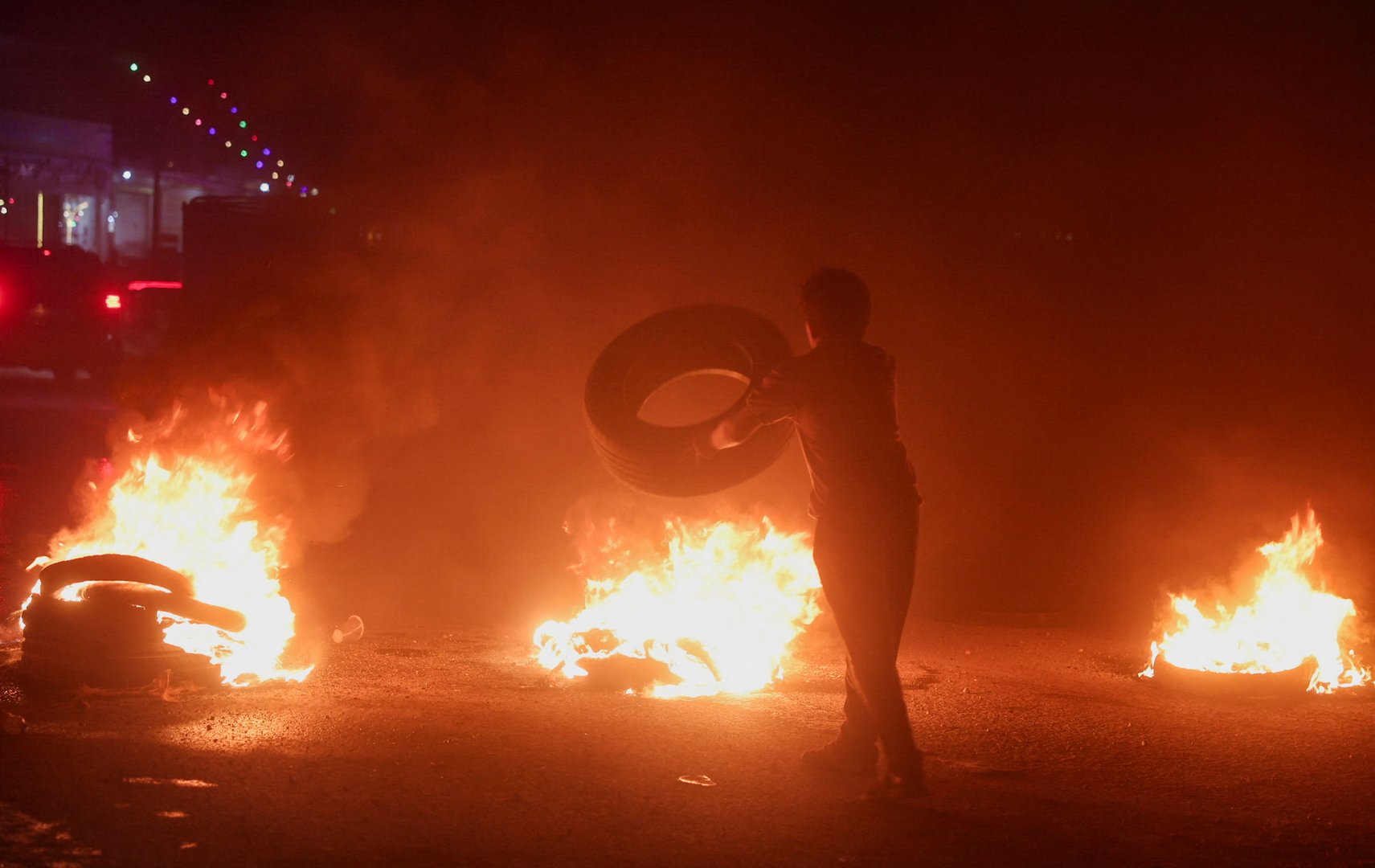 A protester in Aleppo burns tyres to protest the increase in fuel prices in Syria on the highway between Aleppo and Turkey, Syria, September 13, 2026. [REUTERS/Mahmoud Hassano]