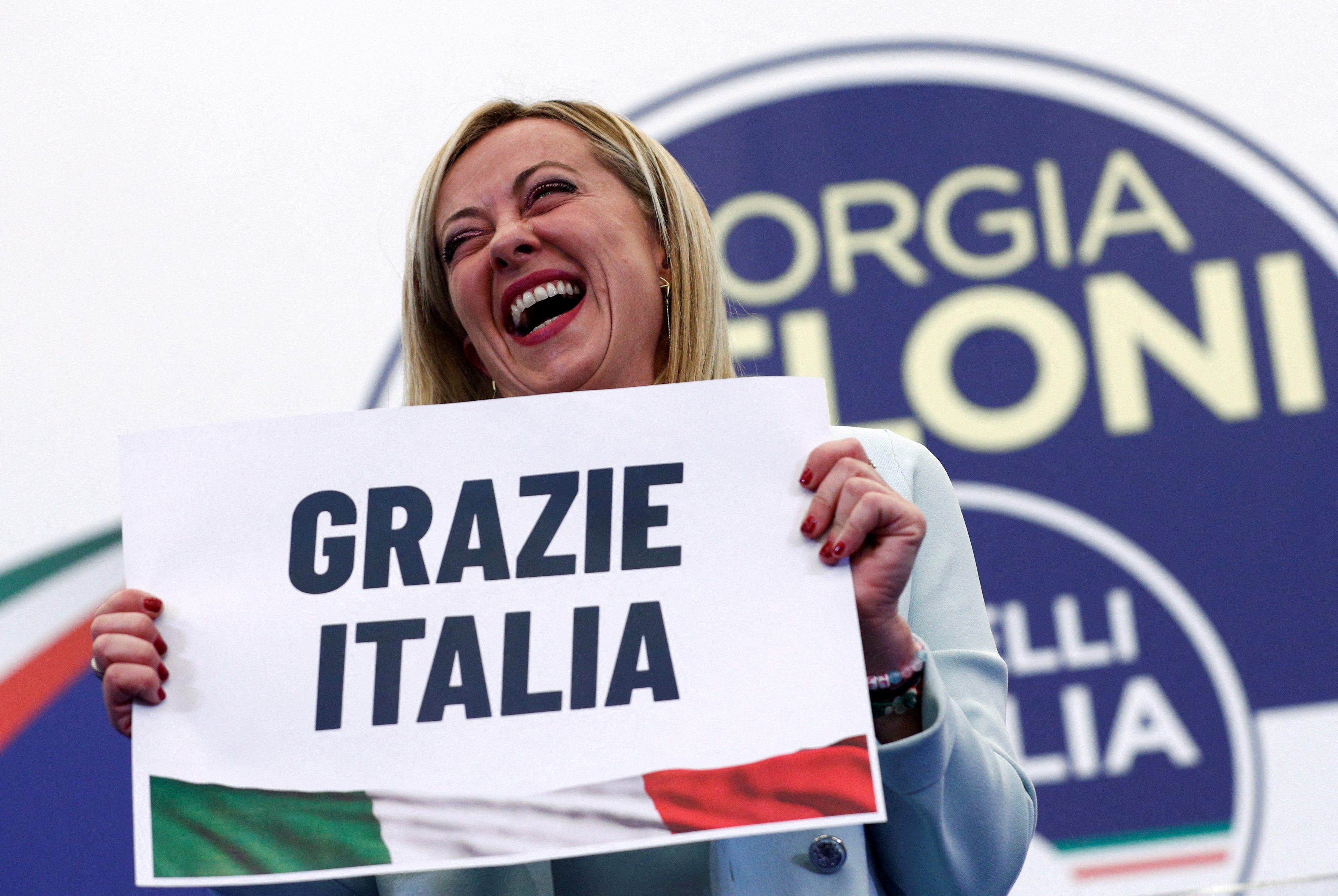 FILE PHOTO: Leader of Brothers of Italy Giorgia Meloni holds a sign at the party's election night headquarters, in Rome, Italy September 26, 2022. REUTERS/Guglielmo Mangiapane/File Photo