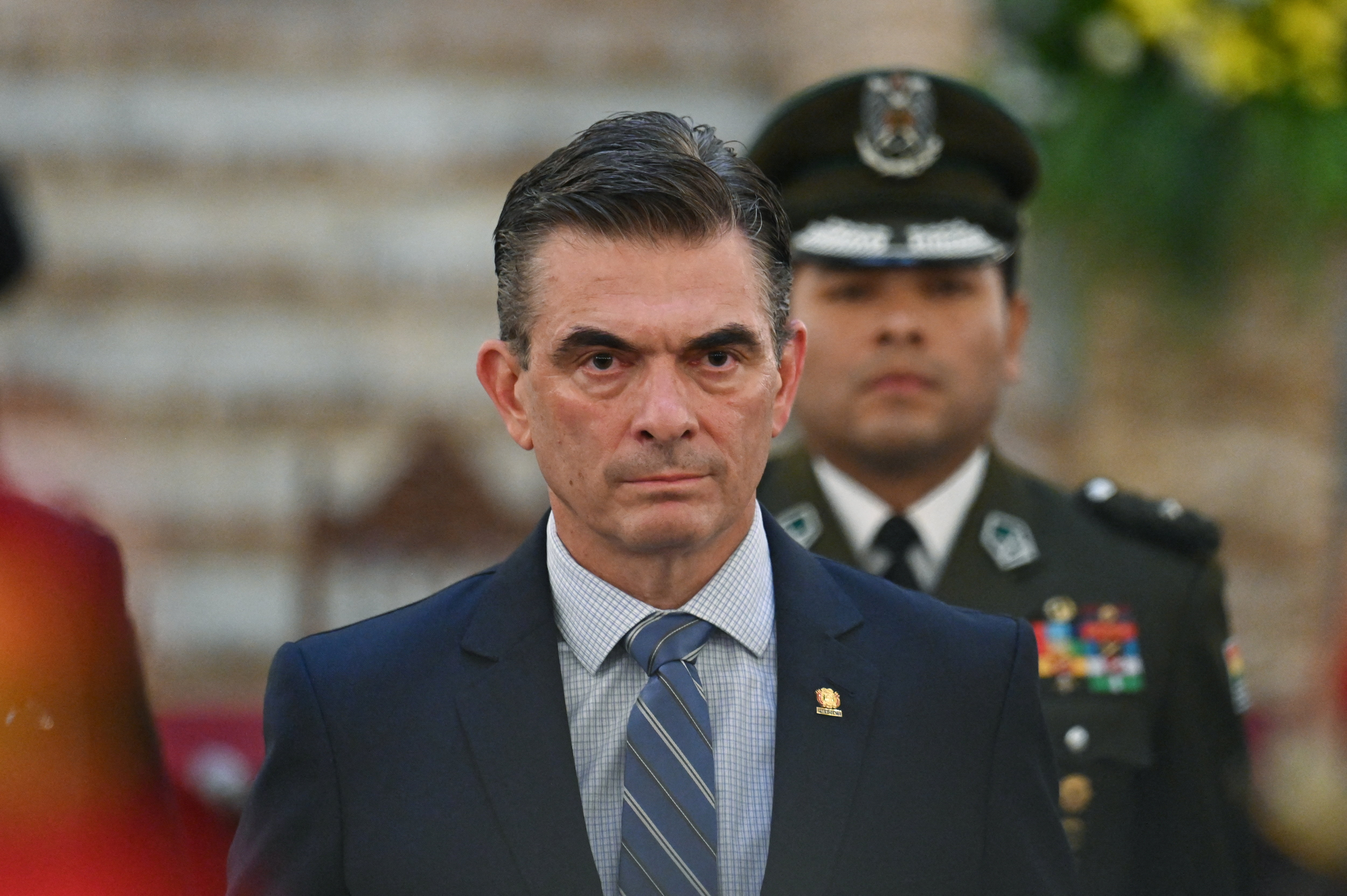 Rodrigo Paz stands at a formal ceremony alongside uniformed police officers.