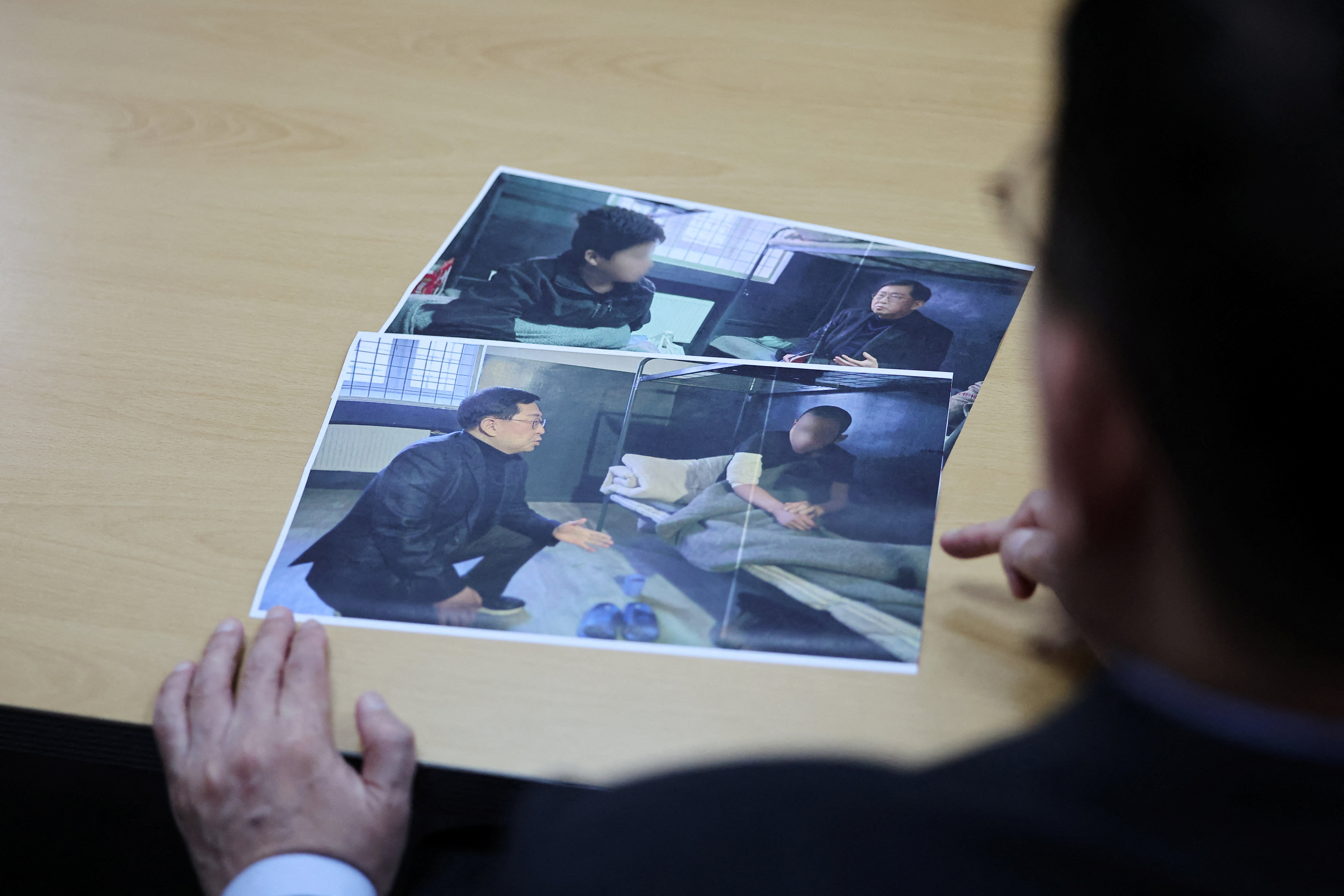 Lawmaker Yu Yong-weon of South Korea’s main opposition People Power Party explains pictures, showing two North Korean POWs who were recently transferred from Ukraine to South Korea, taken during his visit to a POW camp in Ukraine last February, at his office at the National Assembly in Seoul, South Korea, September 28, 2026. Face of POWs are blurred due to security reason by the source. REUTERS/Kim Hong-Ji