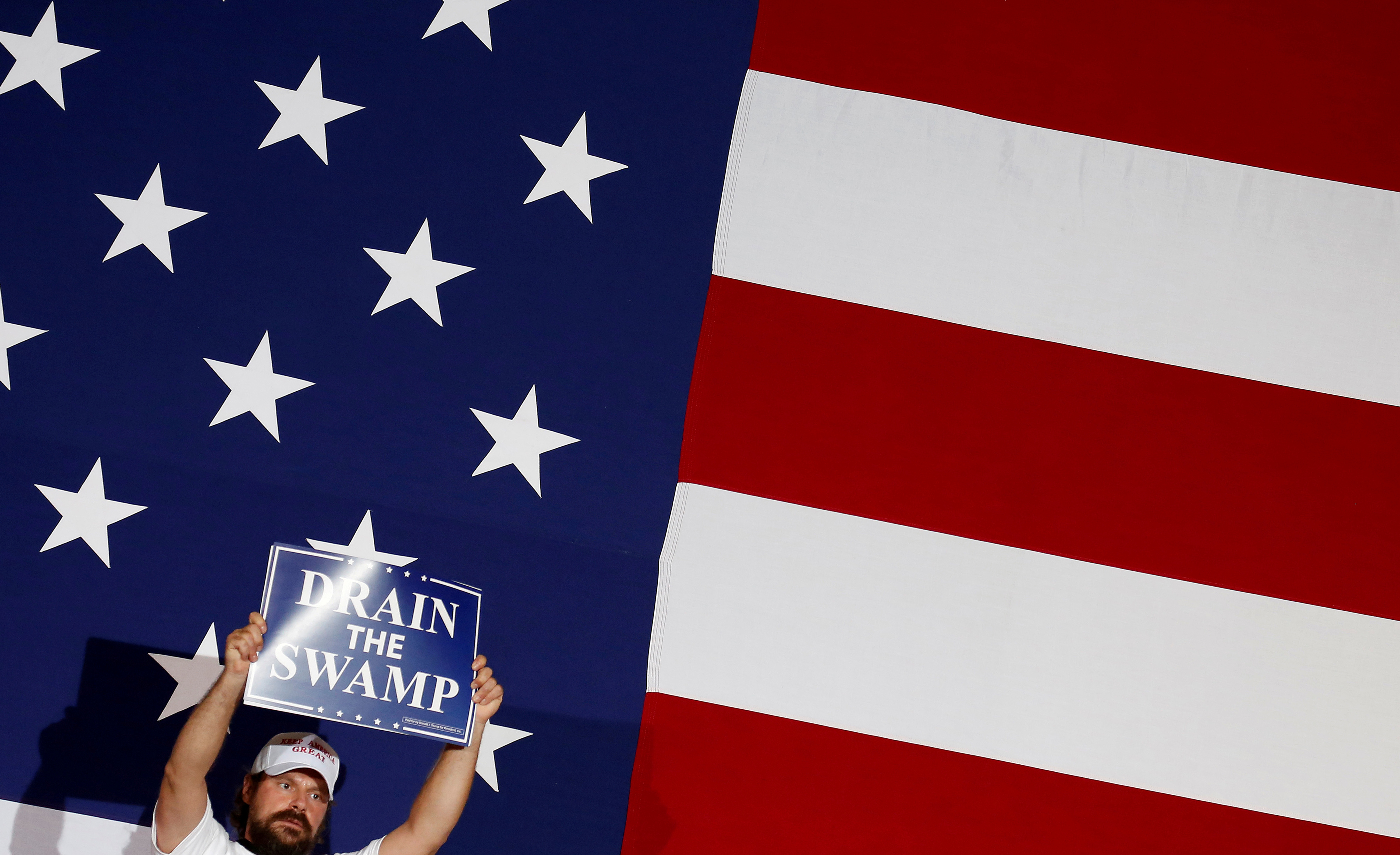 A supporter of U.S. President Donald Trump holds a "Drain the Swamp" sign as he awaits the president's arrival for a "Make America Great Again" rally in Great Falls, Montana, U.S., July 5, 2018. REUTERS/Joshua RobertsA supporter of U.S. President Donald Trump holds a "Drain the Swamp" sign as he awaits the president's arrival for a "Make America Great Again" rally in Great Falls, Montana, U.S., July 5, 2018. REUTERS/Joshua Roberts