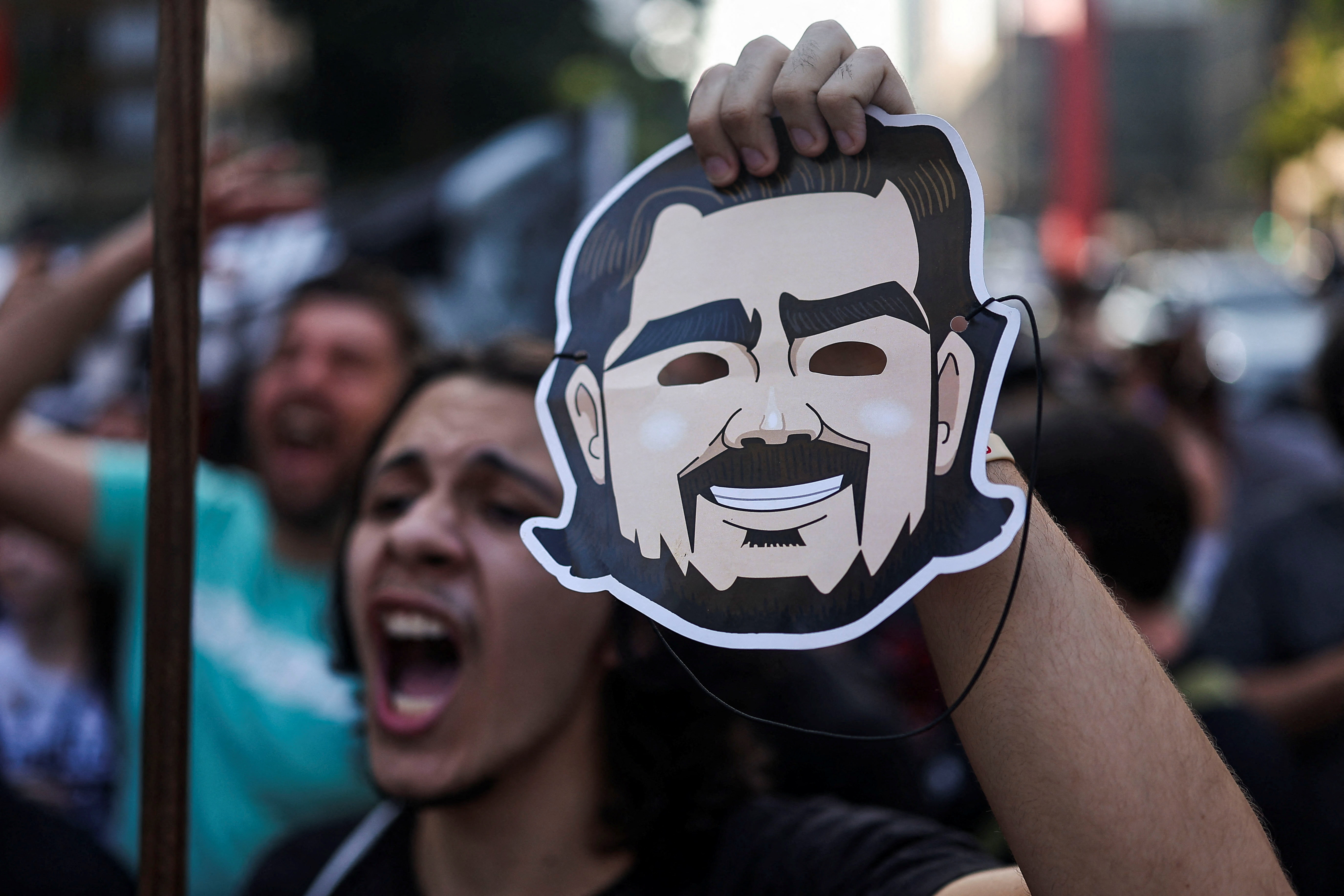 A protester holds a mask depicting businessman Daniel Vorcaro as demonstrators from the right wing group Movimento Brasil Livre (MBL) protest against corruption, following Banco Master's alleged scandals, at Paulista Avenue in Sao Paulo, Brazil, March 21, 2026. REUTERS/Amanda Perobelli