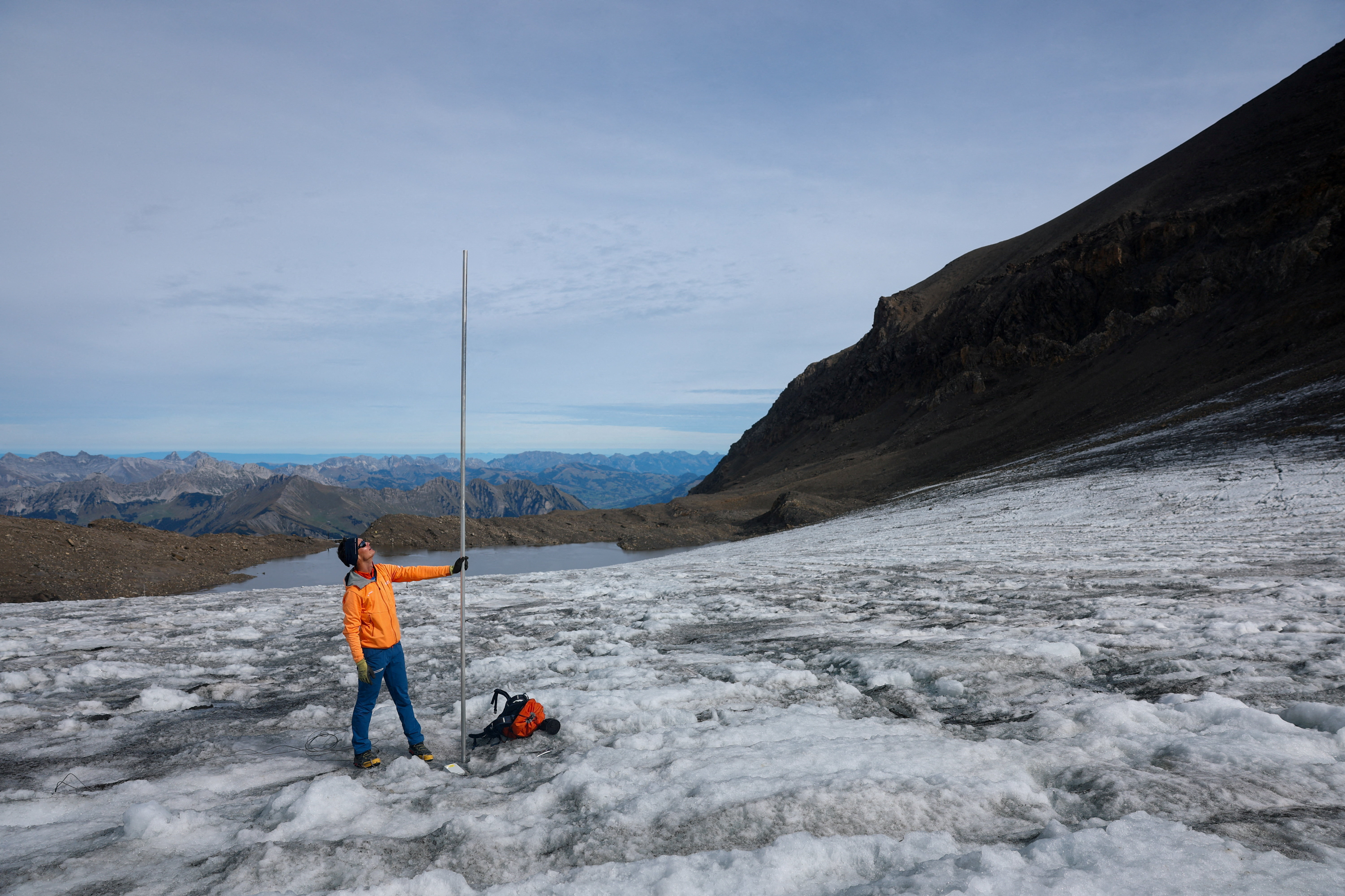 Glaciologist at ETH Zurich and head of GLAMOS Matthias Huss holds a pole that indicates four metres of ice lost over the past year on the Scex Rouge glacier amid climate change at Glacier 3000 in Les Diablerets, Switzerland