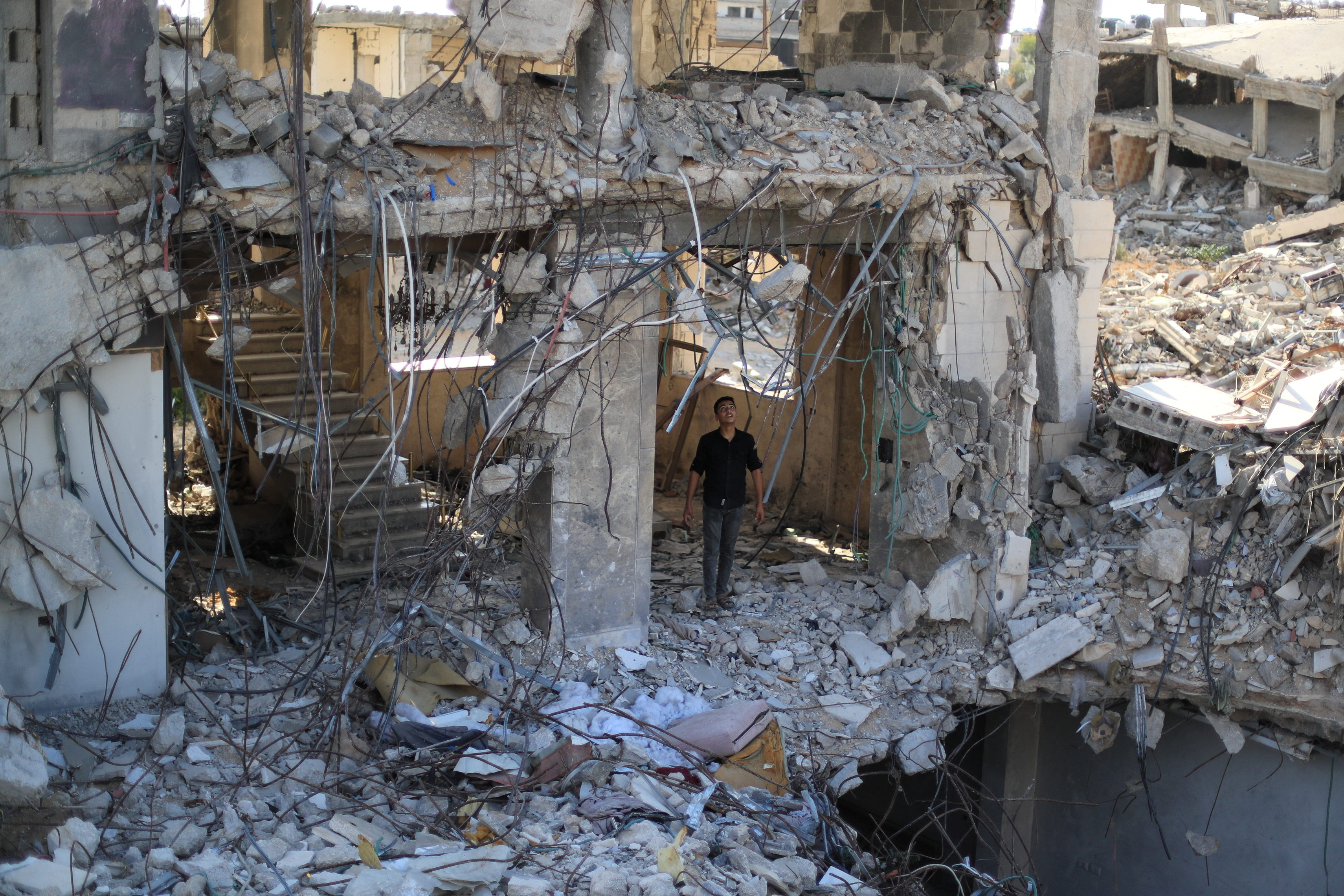 A Palestinian young man stands amid the rubble of residential buildings destroyed during the war, in Gaza City, September 28, 2026. REUTERS/Dawoud Abu Alkas