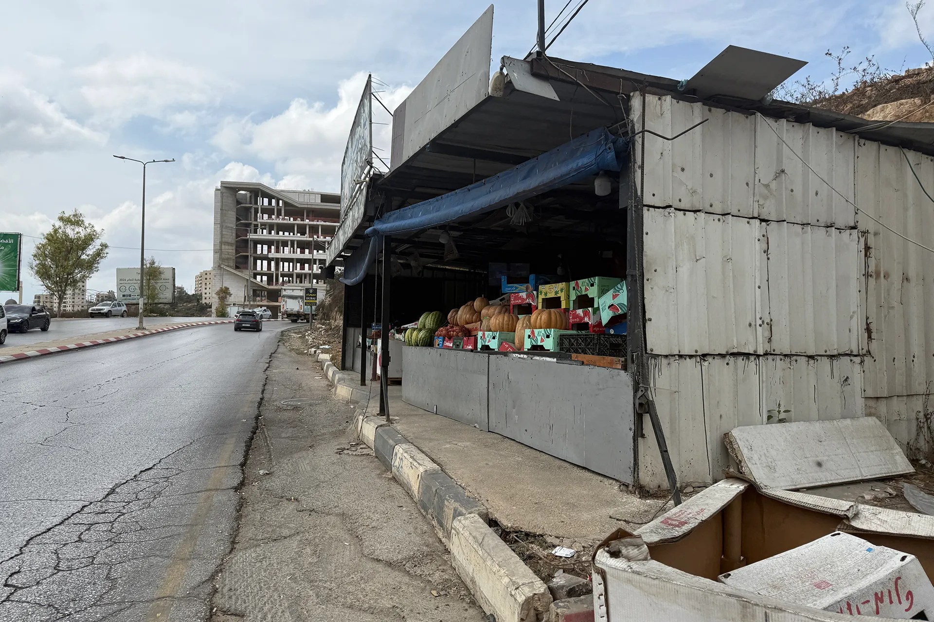 A shack selling fruit on a street.