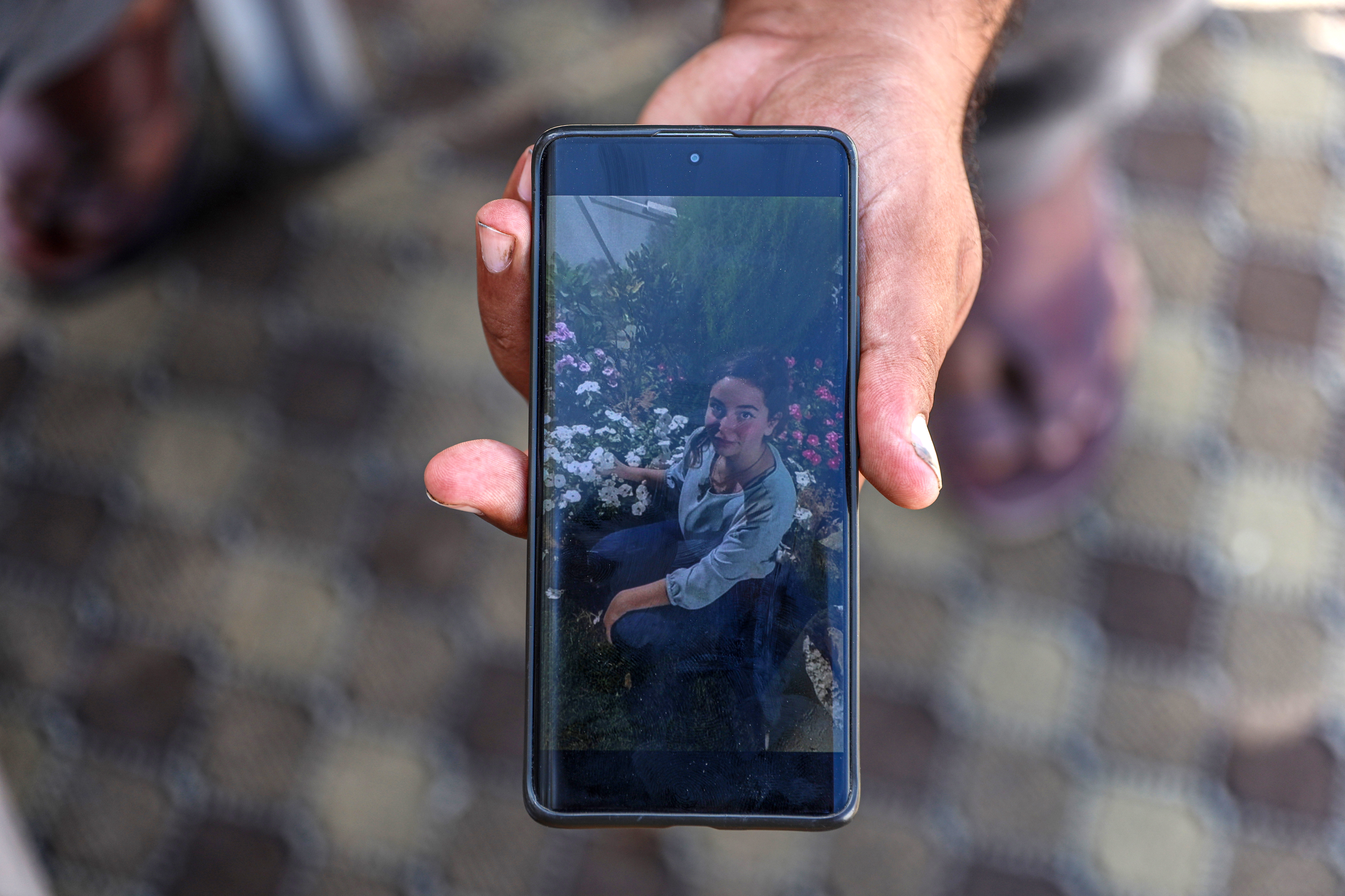Mahmoud holds a photo of his daughter Huda, 12, killed with her mother and siblings.