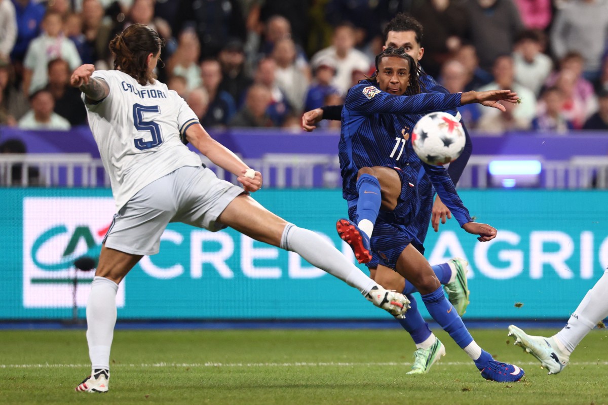 France's midfielder #11 Michael Olise (R) takes a shot in front of Italy's defender #05 Riccardo Calafiori (L) during the UEFA Nations League