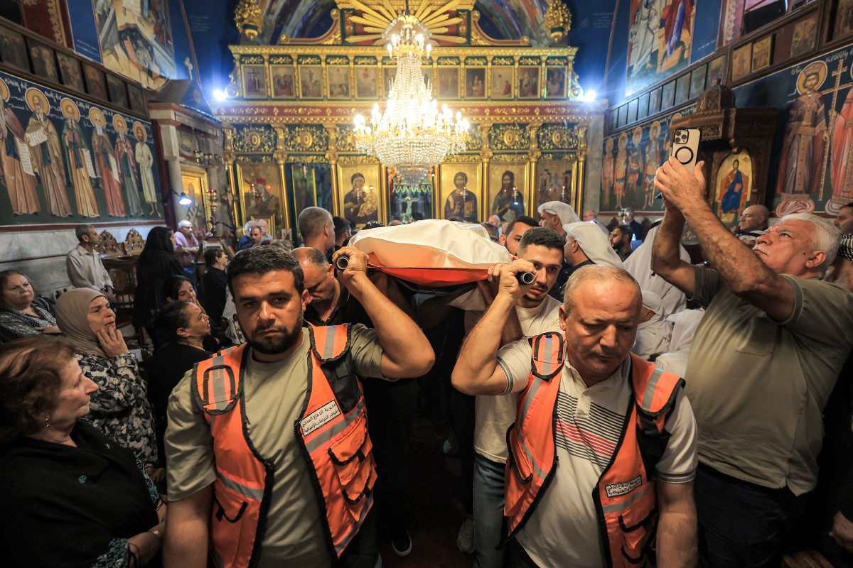Civil Defence members carry the bodies of Maysaa Abu Daoud and her daughter Mary al-Najjar, who were killed following an Israeli strike on a residential building in the Rimal neighbourhood