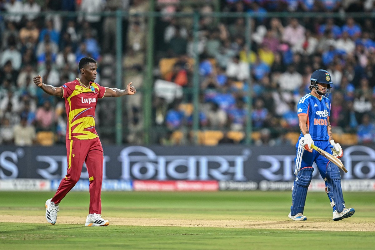West Indies' Shamar Joseph (L) celebrates after taking the wicket of India's Ishan Kishan (R) during the fifth T20 international cricket match between India and West Indies