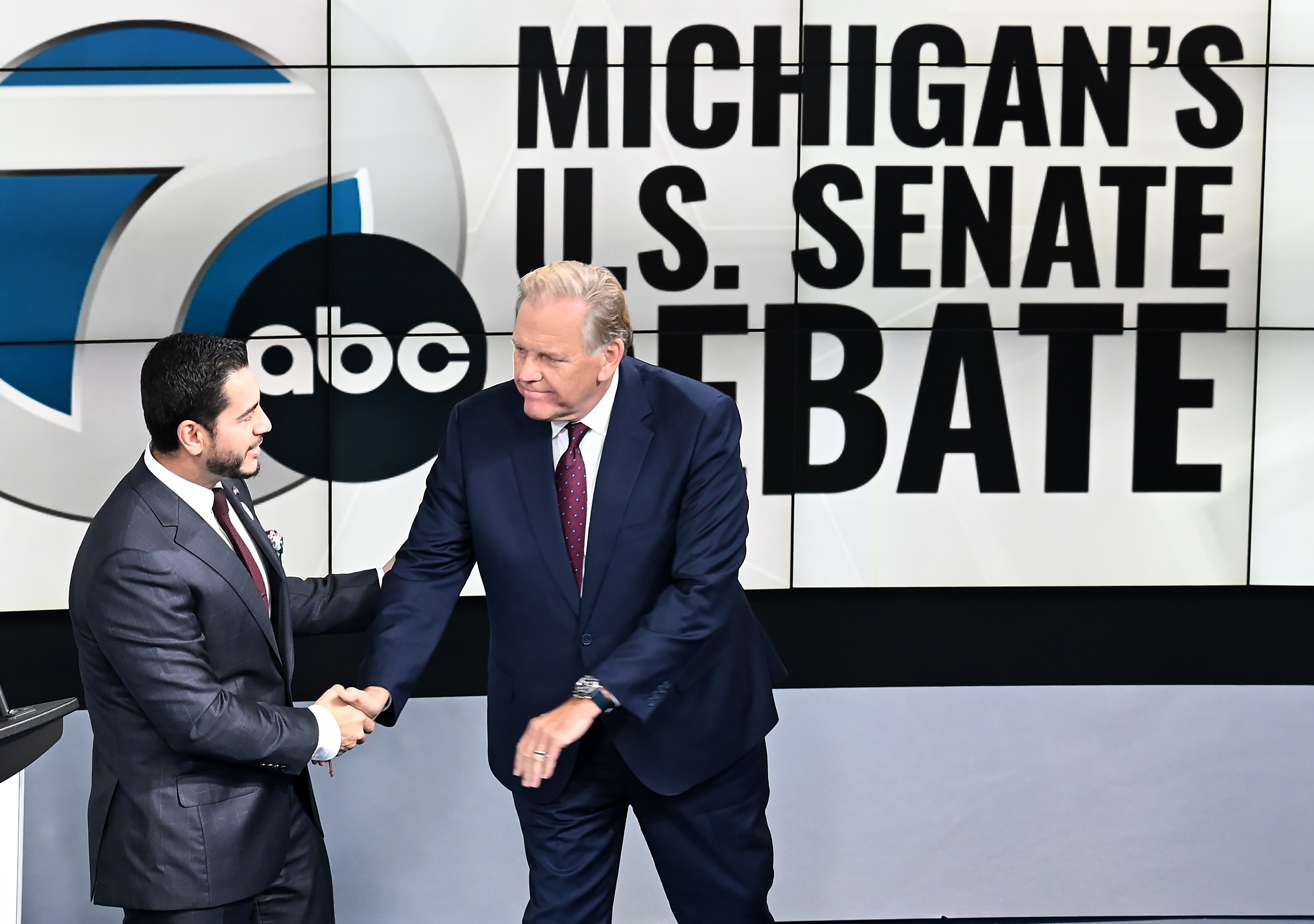US Senate candidates Democrat Abdul El-Sayed, left, and Republican Mike Rogers shake hands before the debate on Wednesday