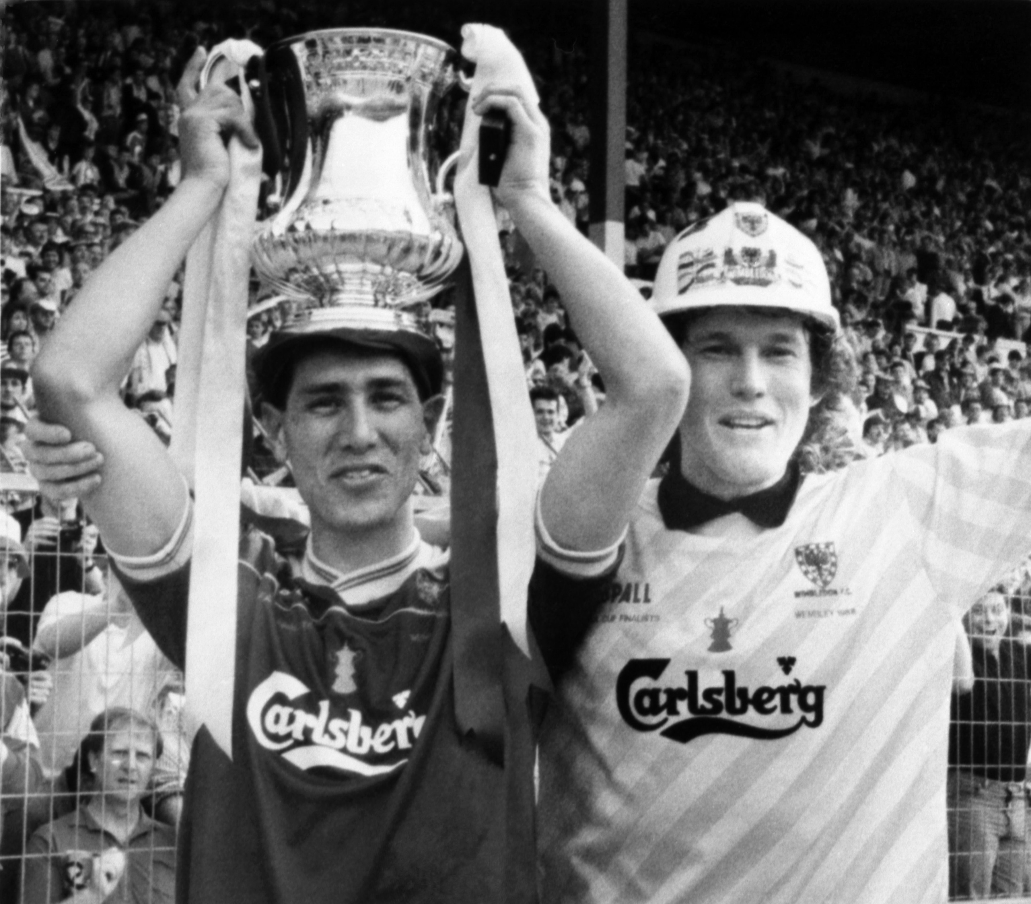 Wimbledon FC player Lawrie Sanchez holds the FA Cup as his captain and goalkeeper David Beasant acknowledges the cheers of their fans on May 14, 1988