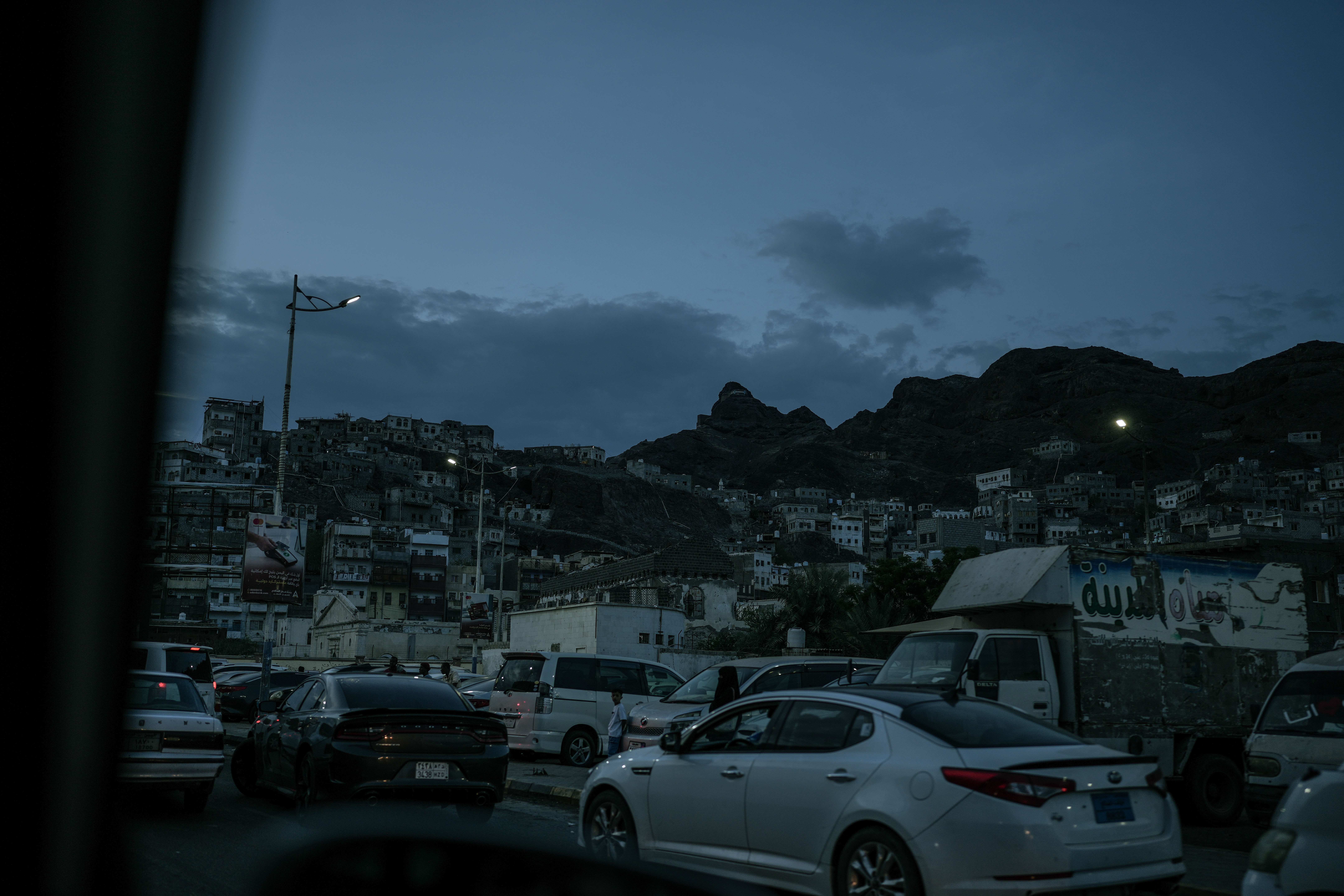 As the sun sets over Aden, parts of the city begin to fall into darkness, with only scattered lights powered by batteries or alternative energy systems. Residents often do not know how long an outage will last or when power will return. Photo: Belal Khaled