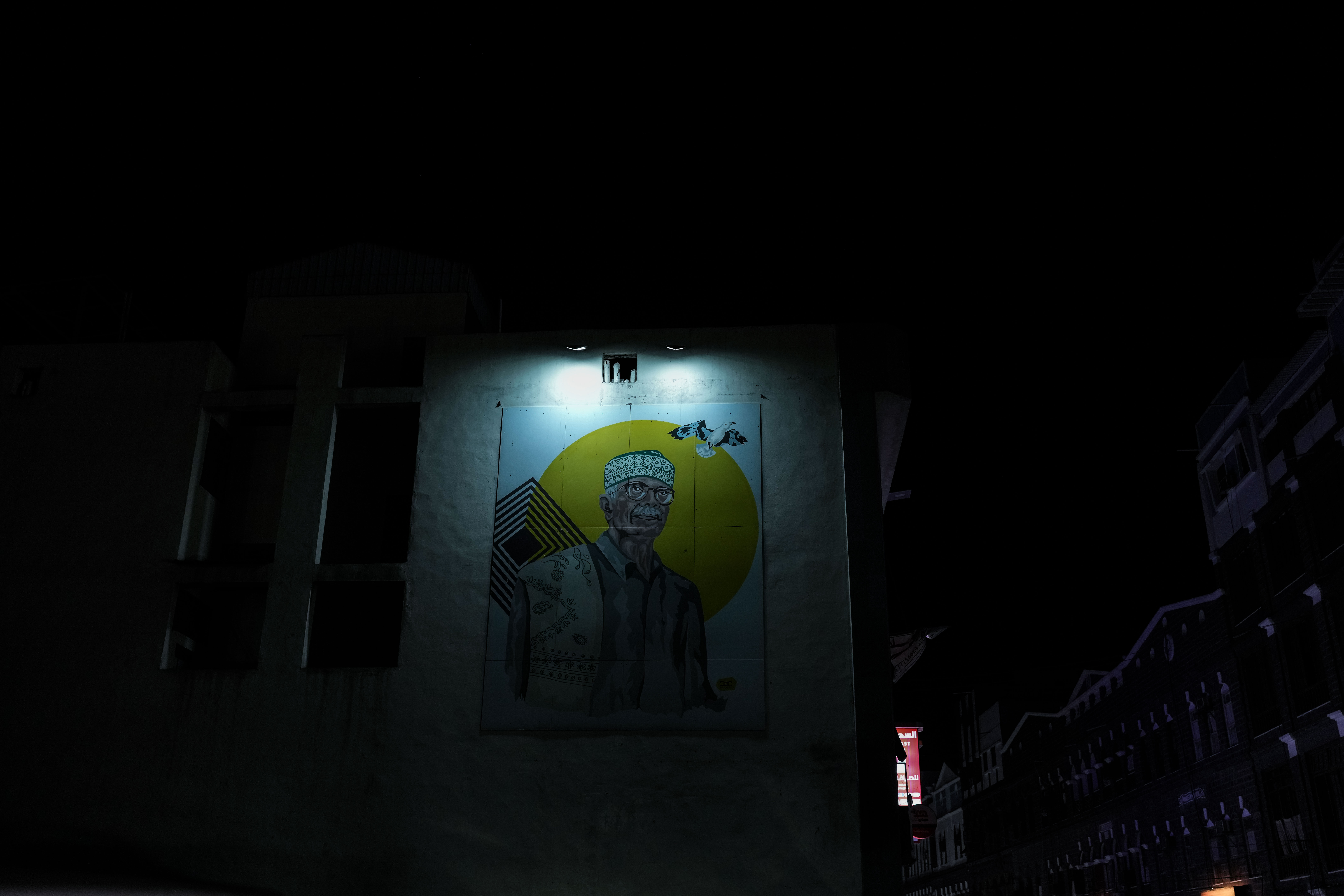 A single light illuminates part of a building in Aden at night while the surrounding area remains dark. After years of repeated electricity cuts, limited pockets of light have become a familiar part of the city’s nightscape.