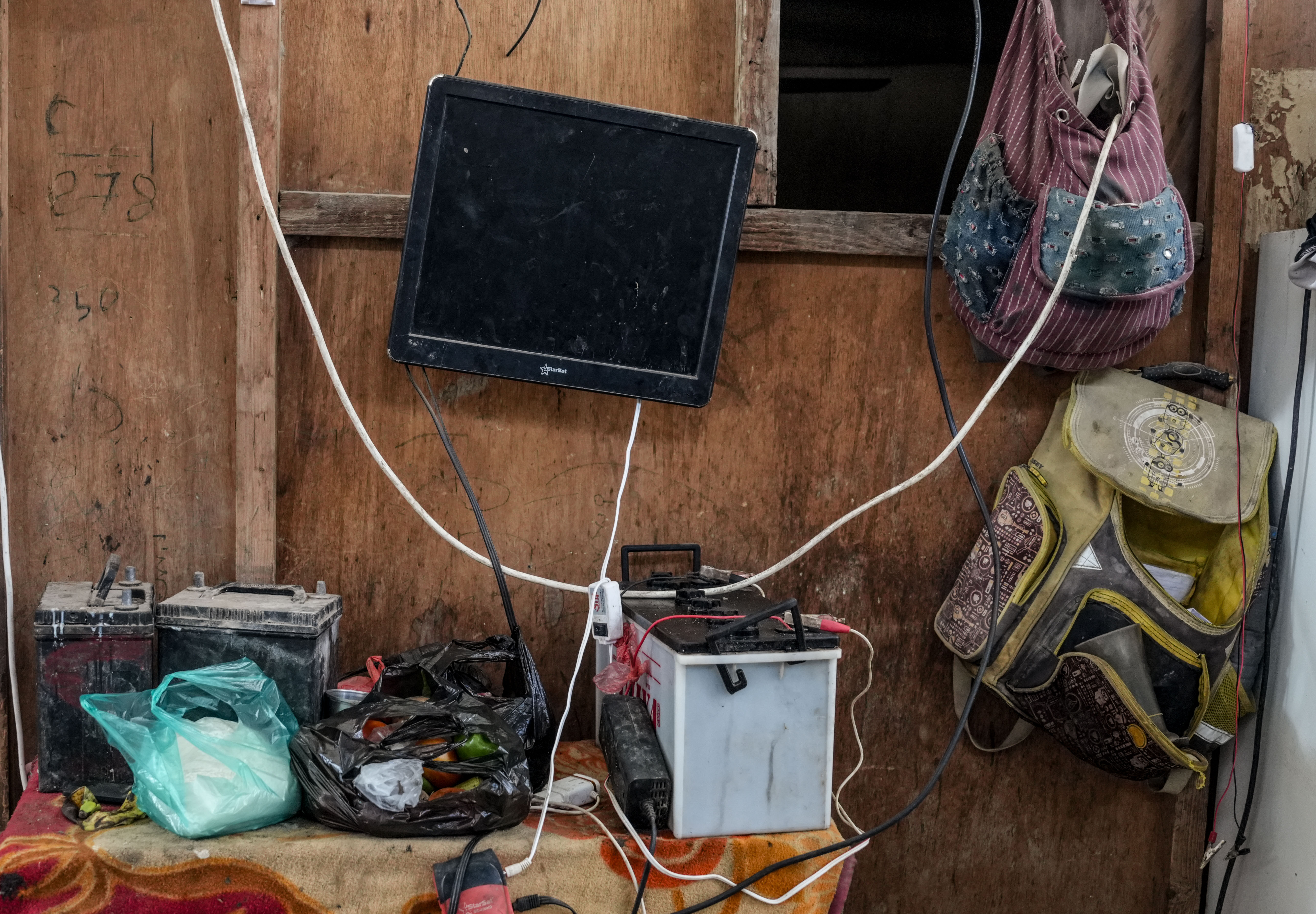 A battery, cables and electrical devices inside a home in Aden, part of the improvised solutions families use to cope with repeated power cuts. For Ghalia Suleiman’s family, the hours when electricity returns are used to charge devices and complete household tasks before the next outage.