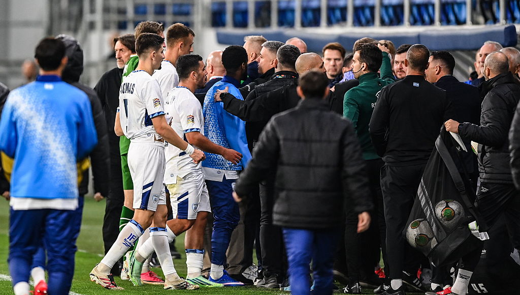 Players and officials tussle as the teams leave the pitch.