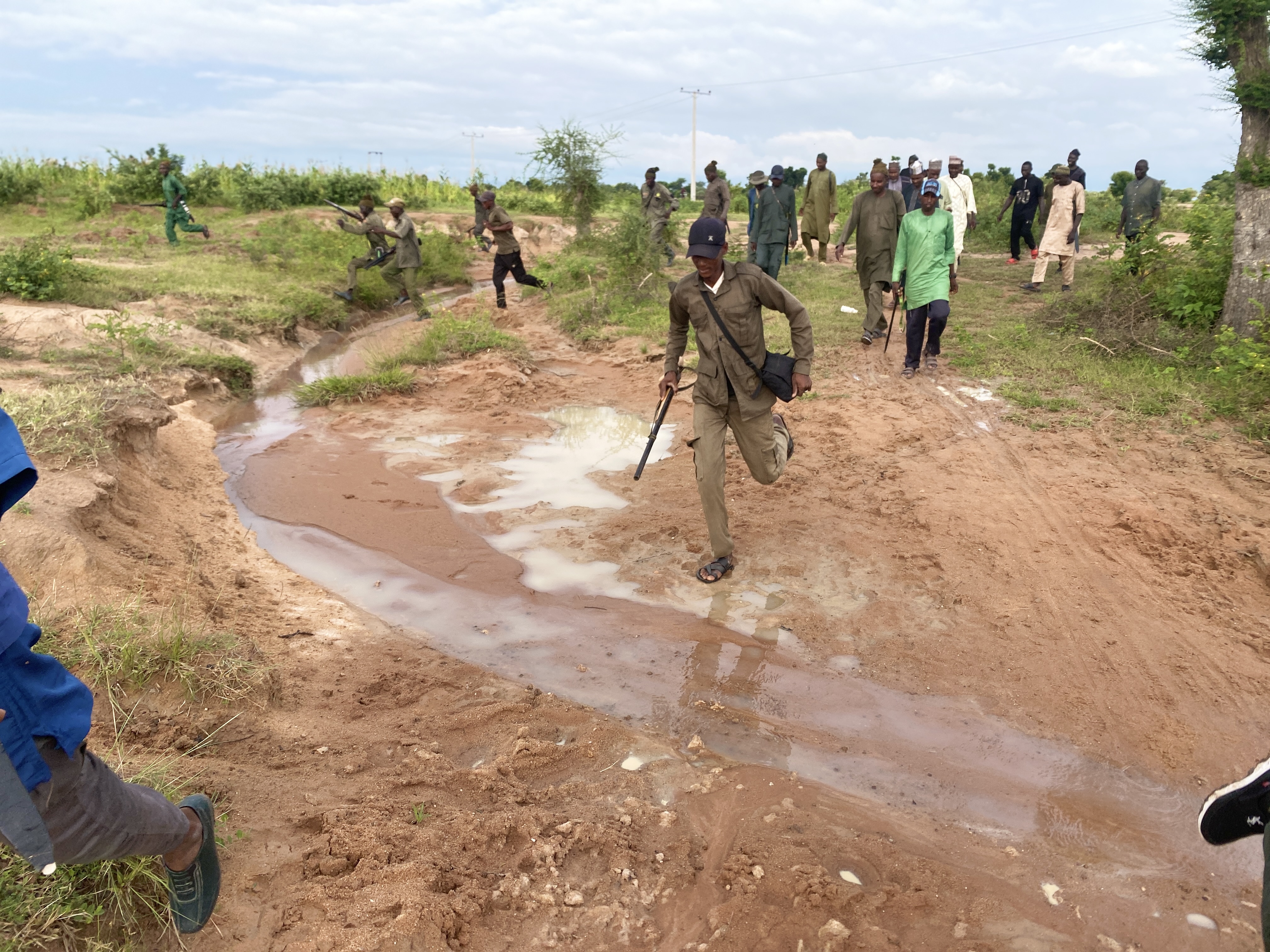 Men run across open terrain during a training exercise in Adamawa State, northeastern Nigeria
