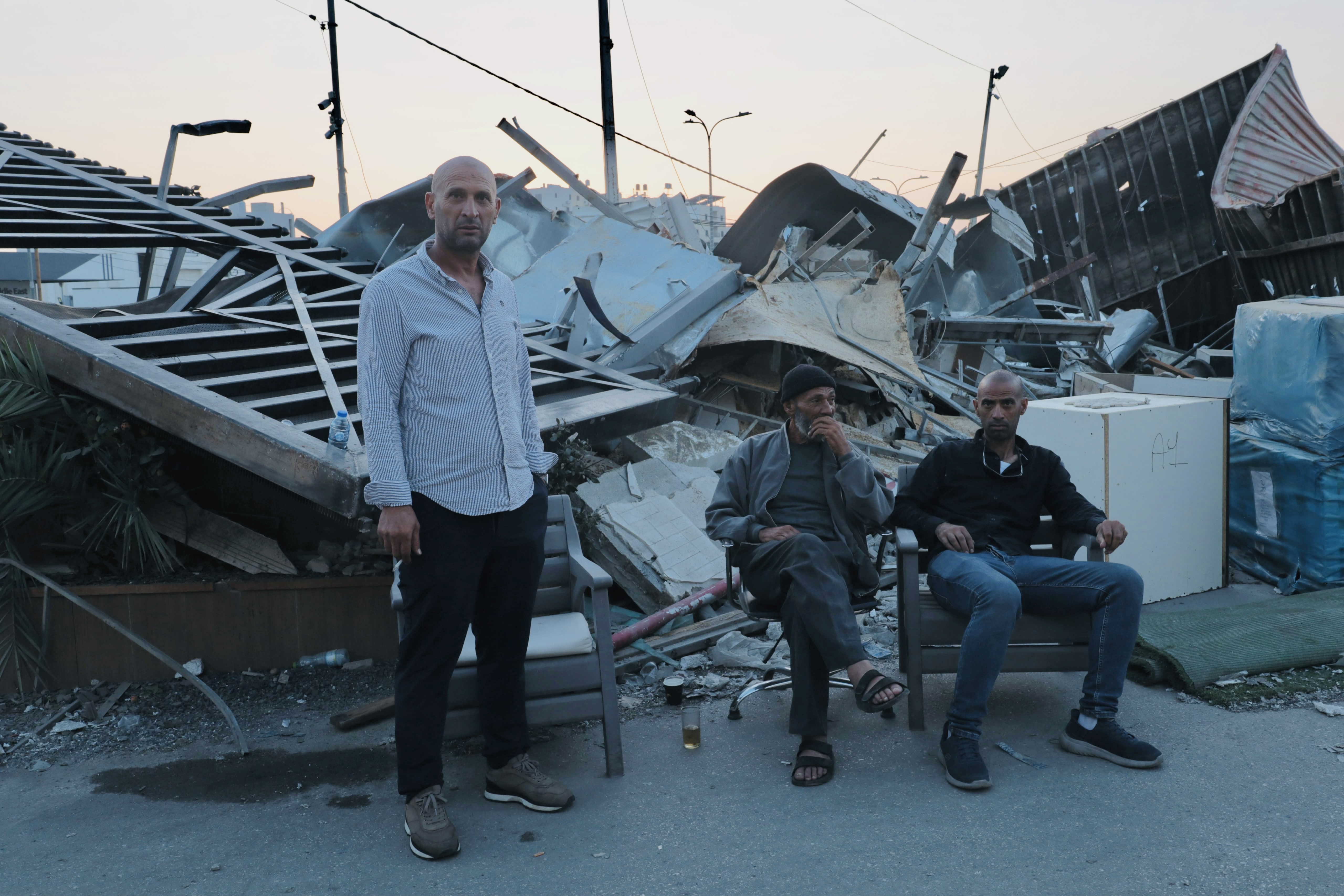 Sufian Qawasmi stands in front of the rubble after demolishing his factory.