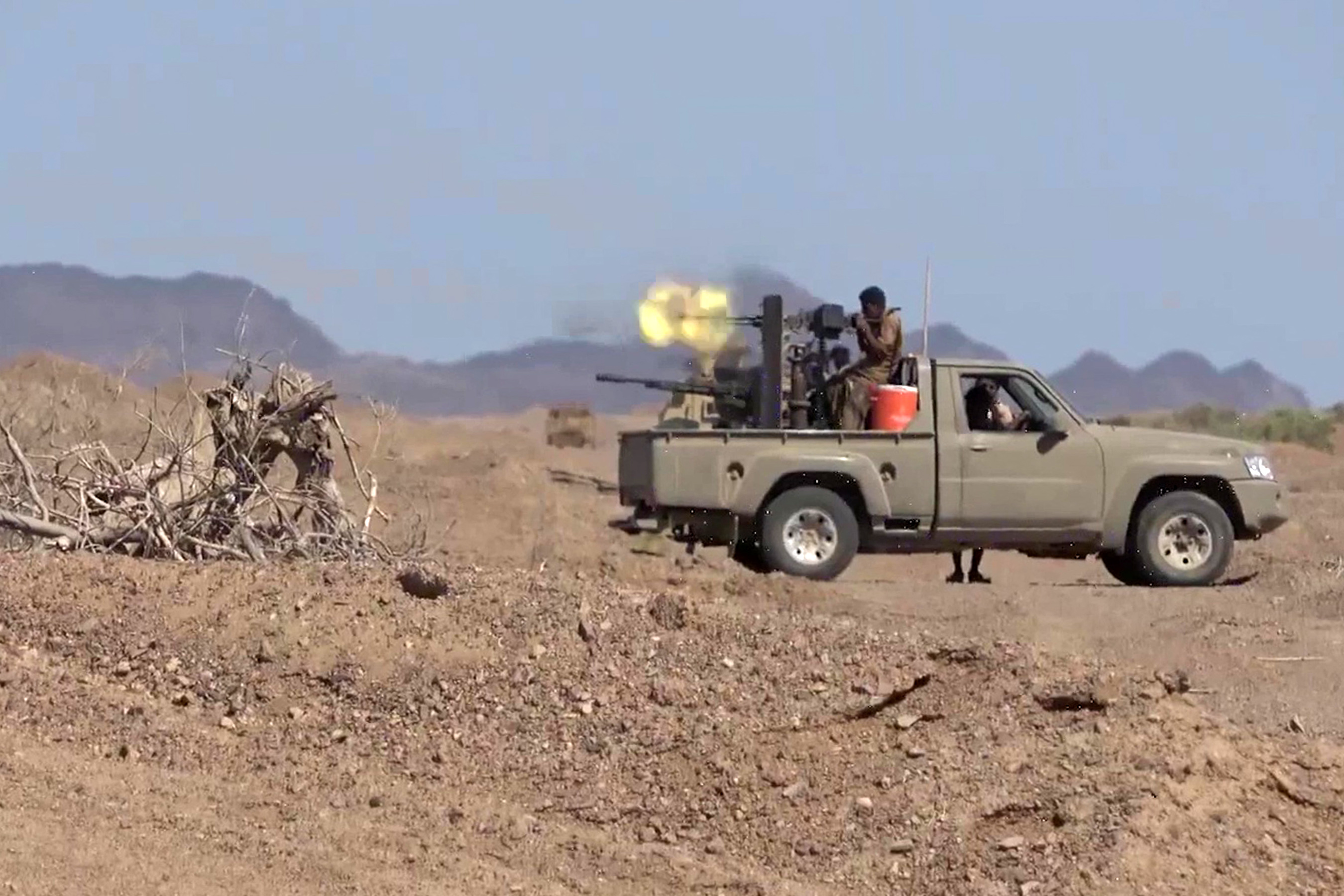 Pro-government fighters fire during clashes with Houthis in Taiz province, Yemen