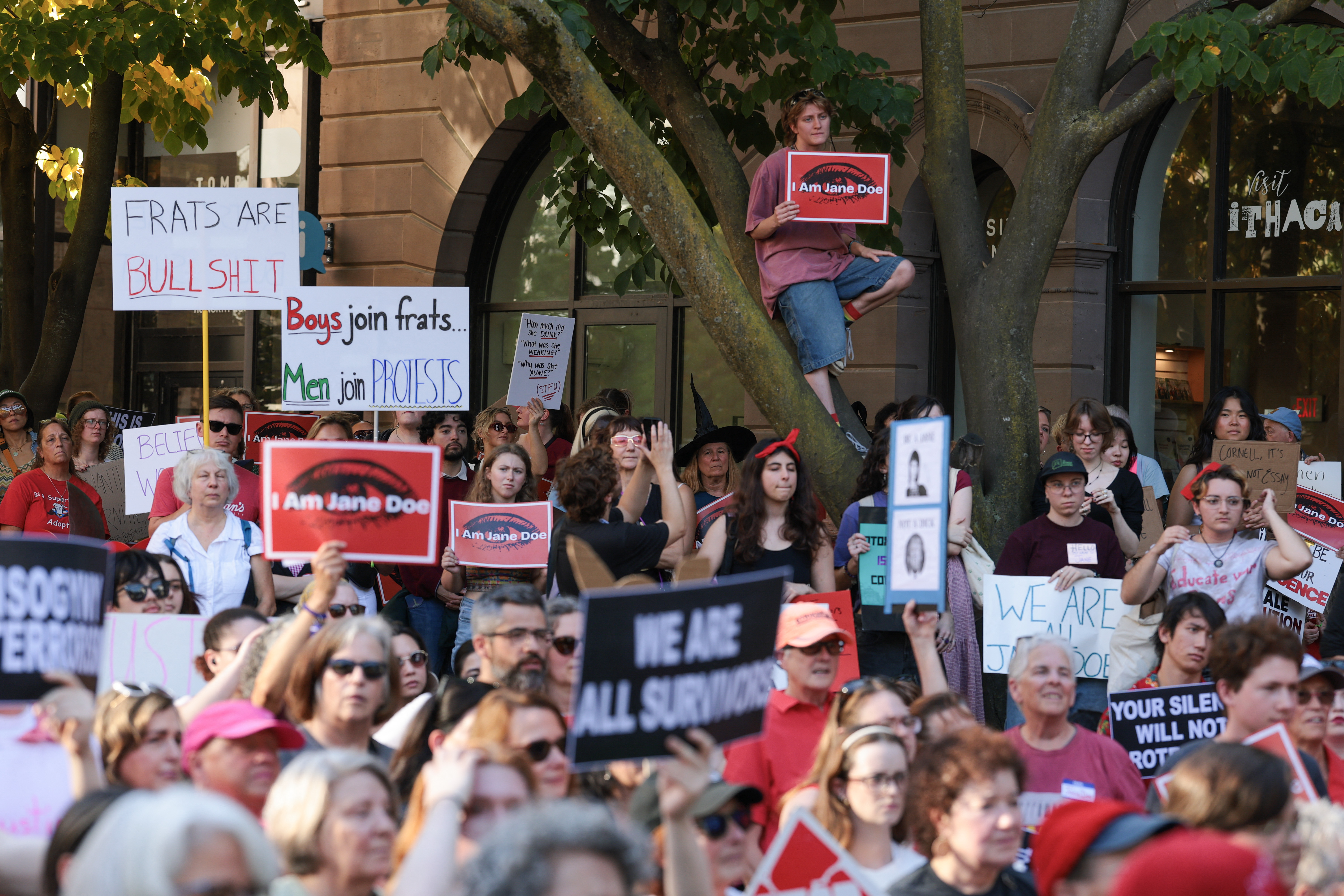 ITHACA, NEW YORK - OCTOBER 13: Protesters listen to speakers at a rally in support of a former Cornell University student known as Jane Doe at the Ithaca Commons on October 13, 2026 in Ithaca, New York. The rally was organized by several survivor and activist groups to demand accountability regarding Jane Doe's alleged gang rape she suffered at the Chi Phi fraternity house in 2024. Officials at Cornell University announced they would ban fraternity parties for the remainder of the academic year as the university continues to face scrutiny over their handling of the 2024 rape allegations. Anna Moneymaker/Getty Images/AFP (Photo by Anna Moneymaker / GETTY IMAGES NORTH AMERICA / Getty Images via AFP)