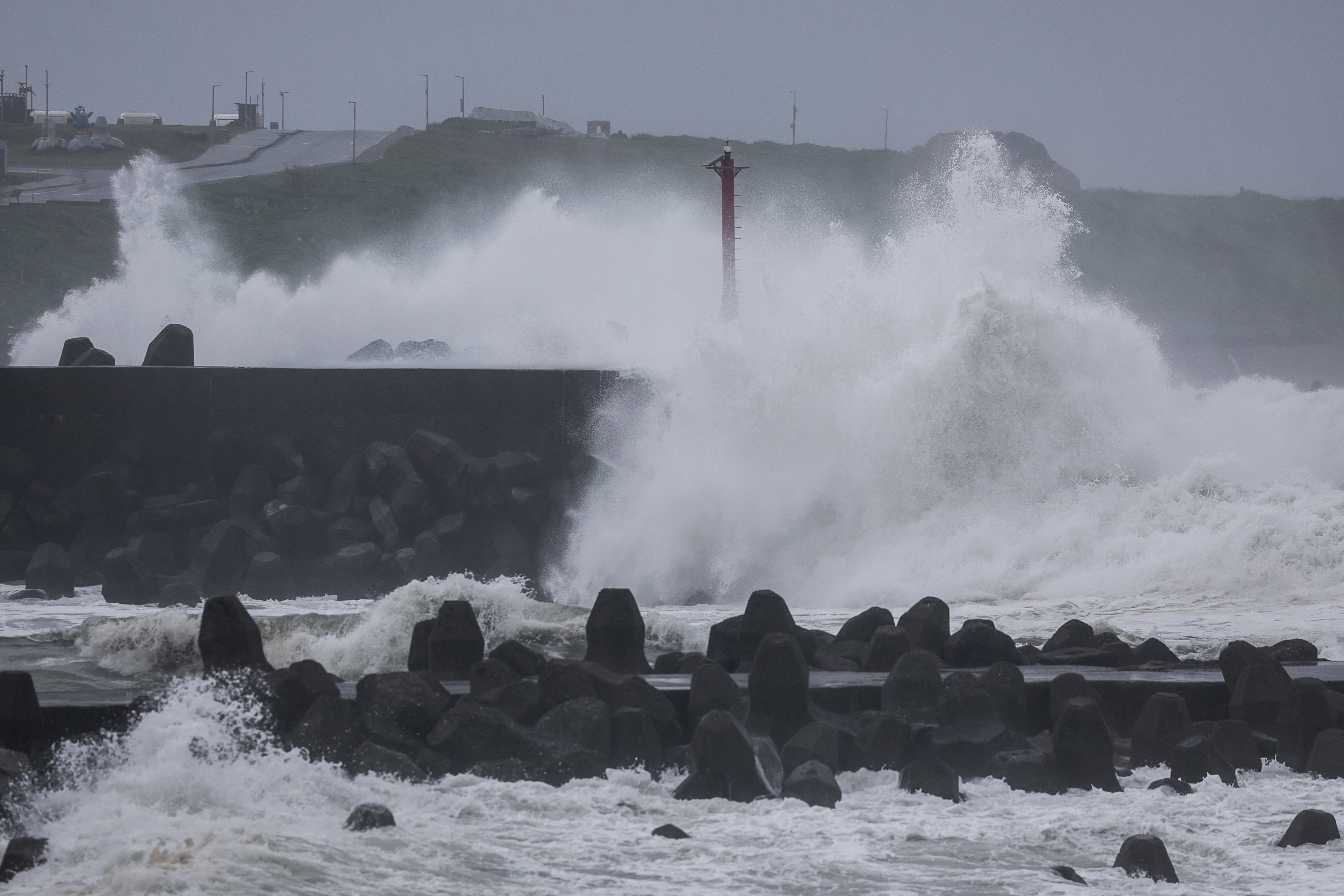 Waves crash against concrete wave breakers along the coast as Typhoon Champi approaches Taiwan, in Keelung on October 23, 2026. (Photo by I-HWA CHENG / AFP)