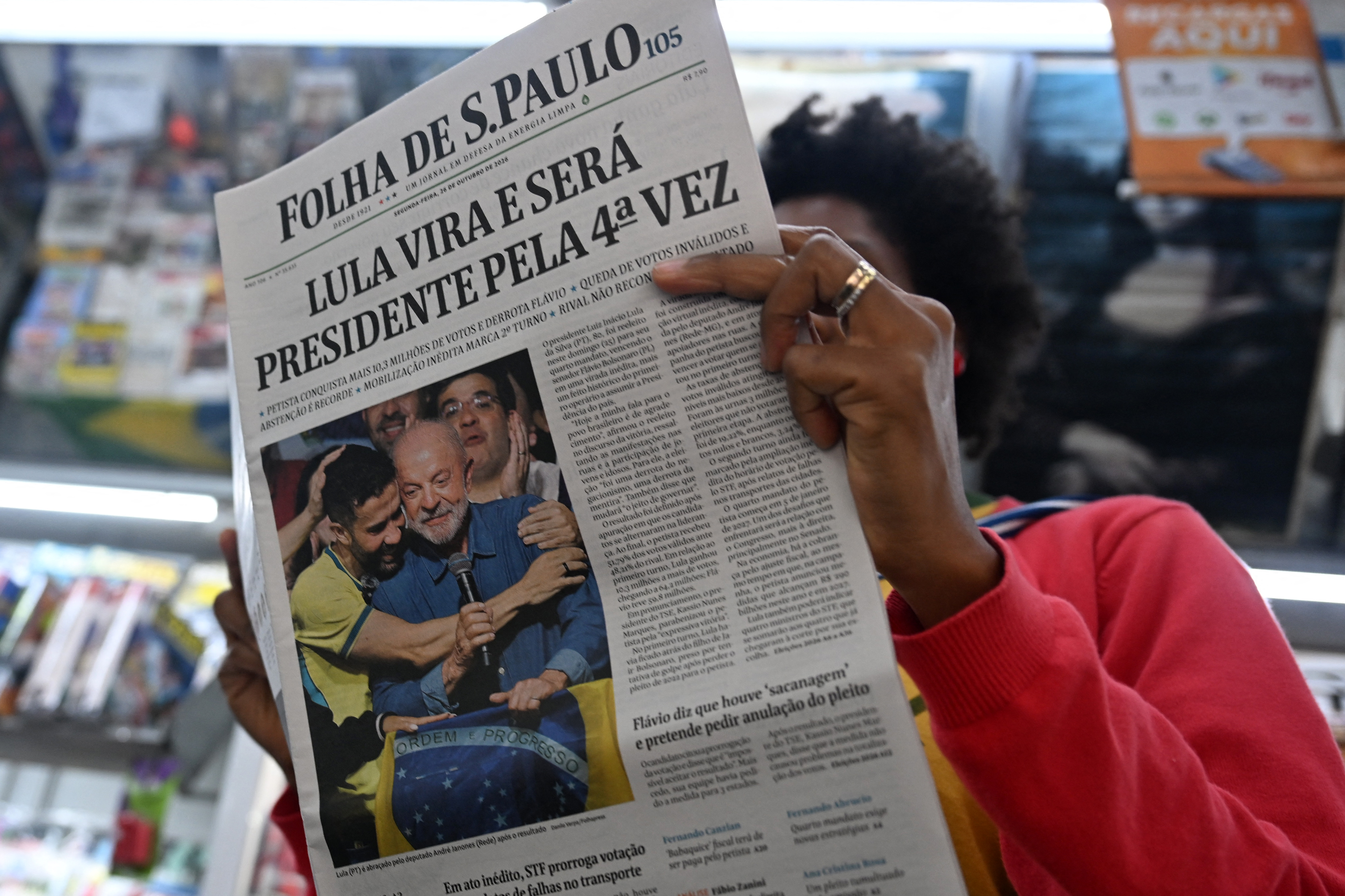 A woman reads a newspaper whose front page displays the victory of Brazil's President and re-election candidate Luiz Inácio Lula da Silva, a day after the presidential runoff election in Sao Paulo, Brazil, on October 26, 2026.