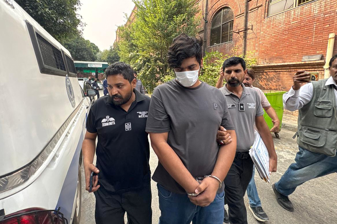 Police officers escort a detained suspect.
