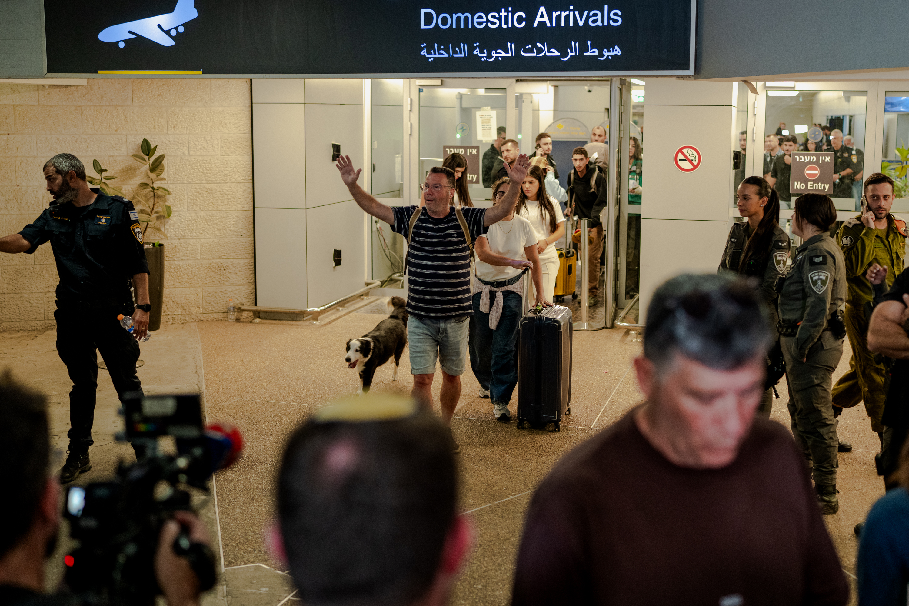 TZAFRIA, ISRAEL - SEPTEMBER 30: A passenger raises his arms in relief as he walks through the domestic arrivals doors with his dog and luggage at Ben Gurion Airport on September 30, 2026 in Tzafria, Israel. This morning, a Flydubai flight from Dubai to Tel Aviv was diverted to Saudi Arabia after a violent altercation in the cockpit. Passengers told media outlets that a pilot was stabbed and temporarily lost control of the plane. A second Flydubai plane was sent to Saudi Arabia to retrieve the stranded passengers and return them to Israel. (Photo by Erik Marmor/Getty Images)