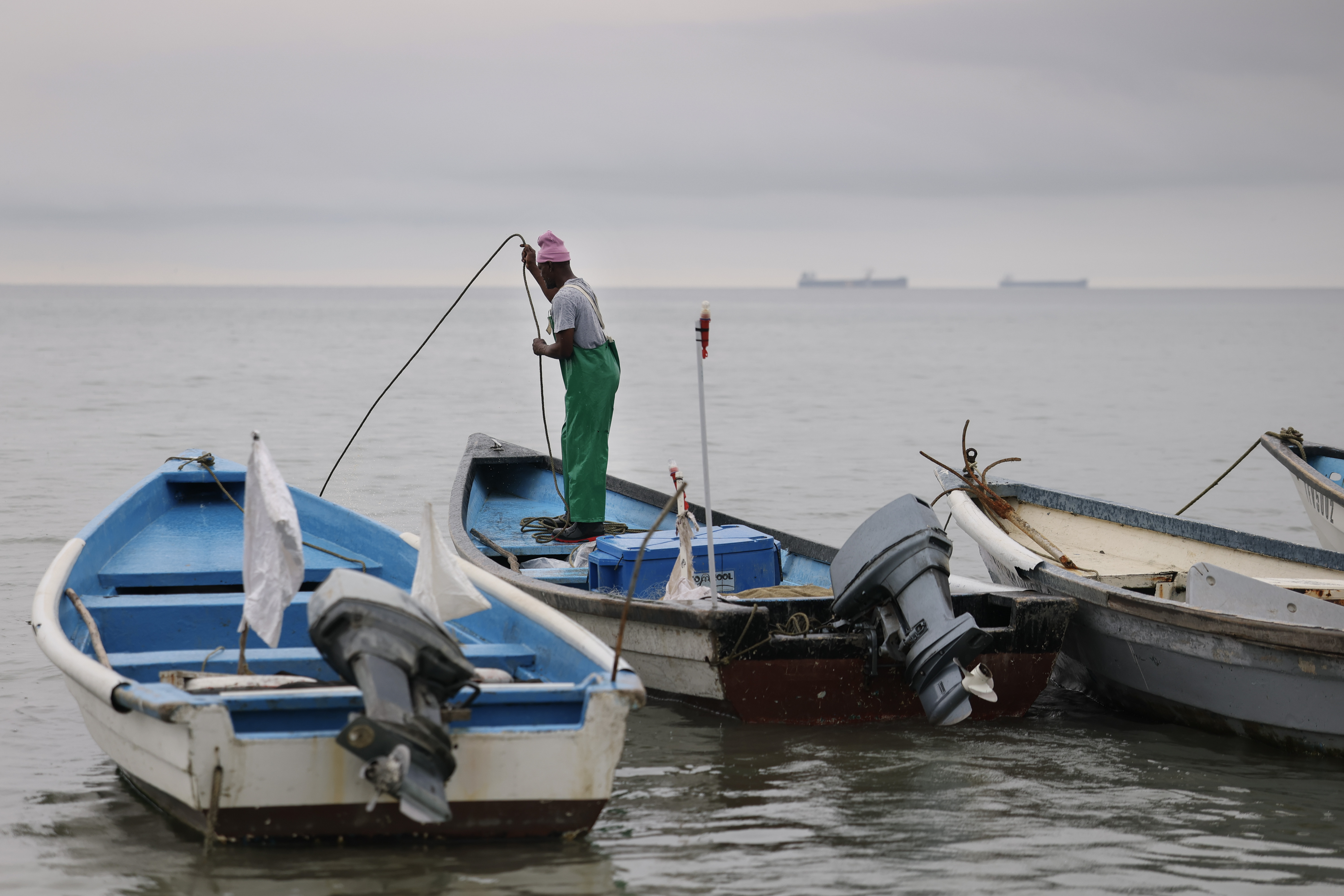 a man on a small fishing boat in a harbour