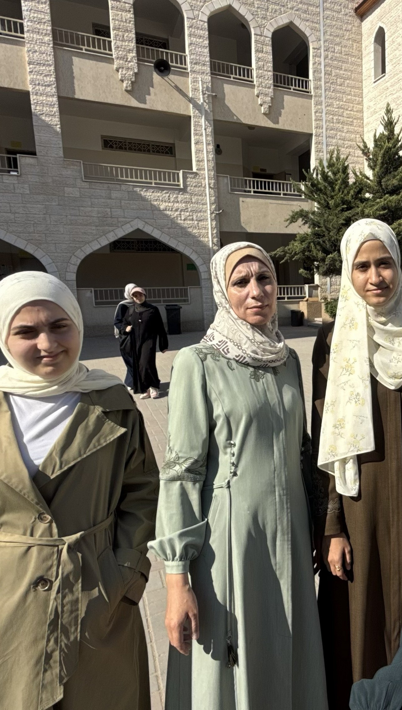Yasmin Abu Zaid [L], teacher Maha Taha, and Lina Yunis Abd al-Qader in the schoolyard