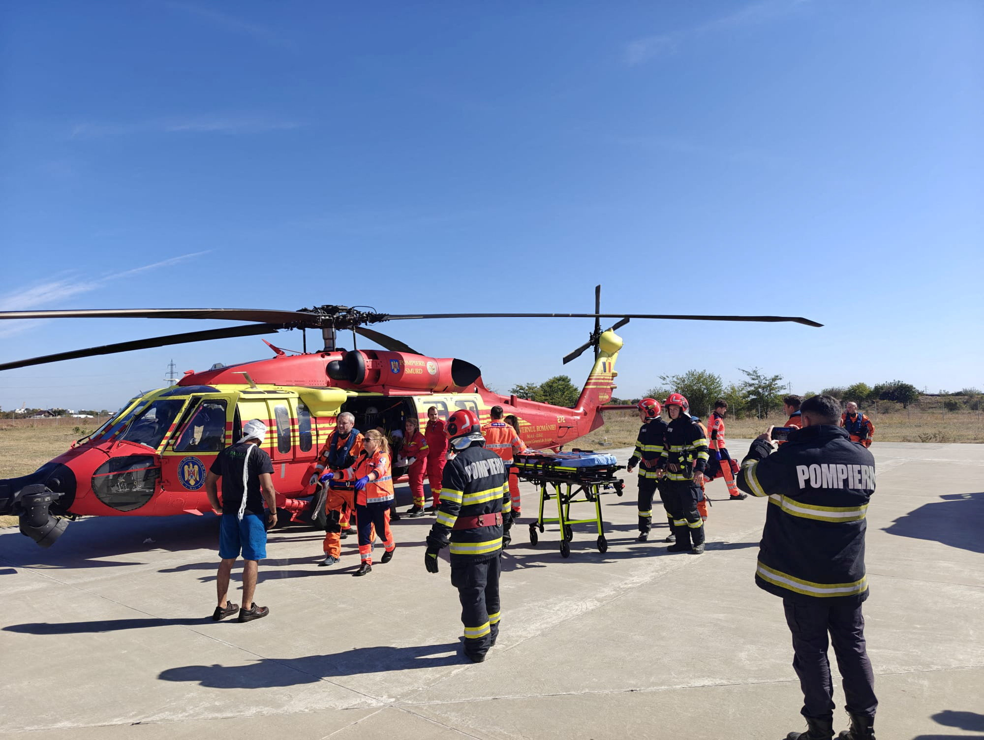 Firefighters and rescuers work near a helicopter at an emergency helicopter base in Constanta, Romania, during a rescue operation following a maritime incident involving a fire aboard a vessel outside Romania's territorial waters, in which two people died and others were rescued, in this handout image released on October 5, 2026. Romanian Interior Ministry/Handout via REUTERS ATTENTION EDITORS - THIS IMAGE HAS BEEN SUPPLIED BY A THIRD PARTY. NO RESALES. NO ARCHIVES
