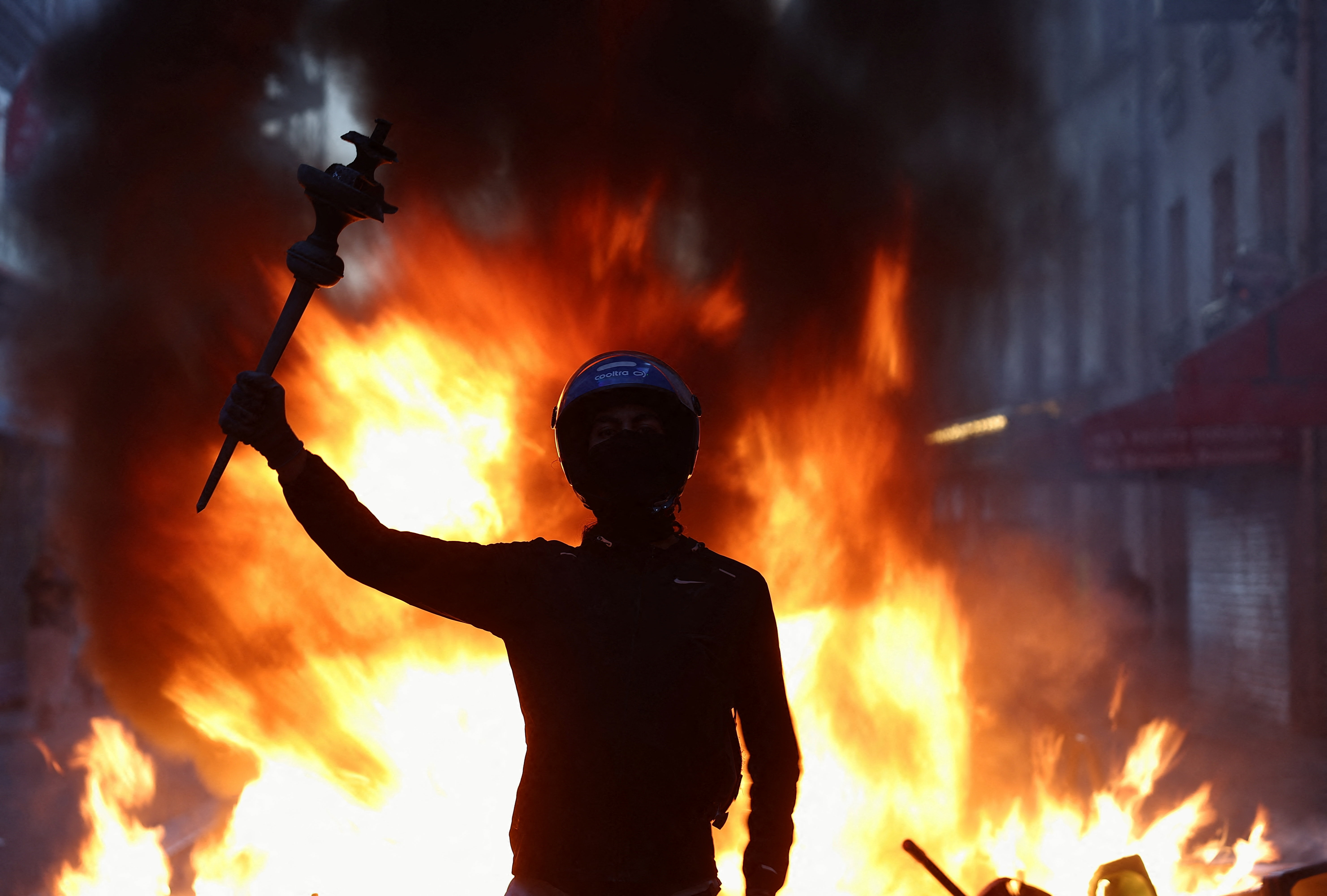 A person raises their arm during civil unrest, the day after a national day of demonstrations against the cost of living and rising fuel prices, in Paris, France, October 18, 2026. REUTERS/Abdul Saboor TPX IMAGES OF THE DAY