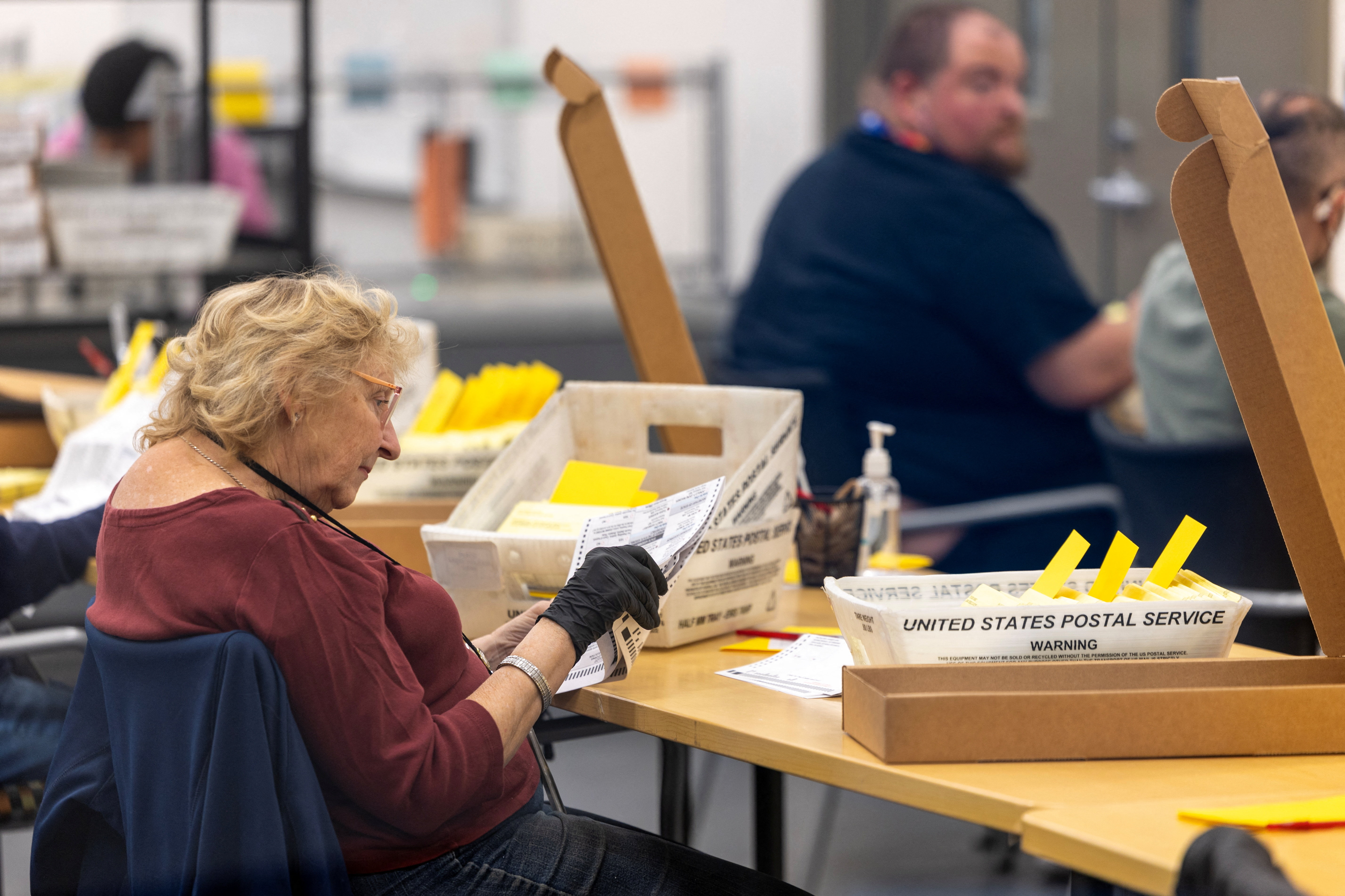 Election workers extract ballots as they help process mail-in ballots at the Registrar of Voters facility in San Diego, California, US, October 23, 2026. REUTERS/Mike Blake